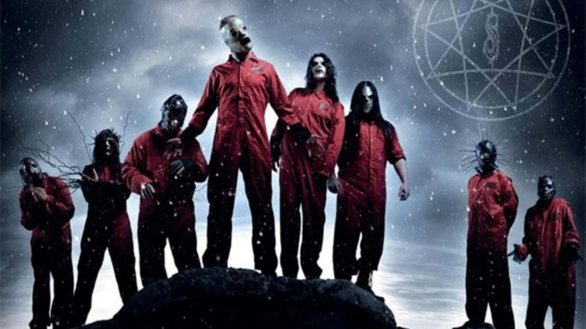 Slipknot 桌布 壁紙 — 七個戴面具、身穿紅色連身衣的人物站在岩石上，天空風暴密佈，雲中有一個發光的五角星。