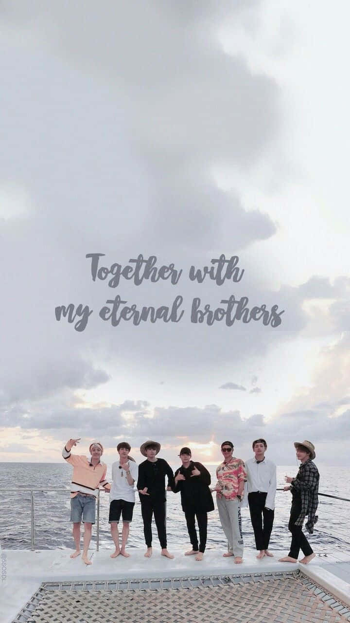 Bangtan Sonyeondan 桌布 壁紙 — 七個男人赤腳站在船甲板上，在日落時微笑，背後是陰天和海洋。