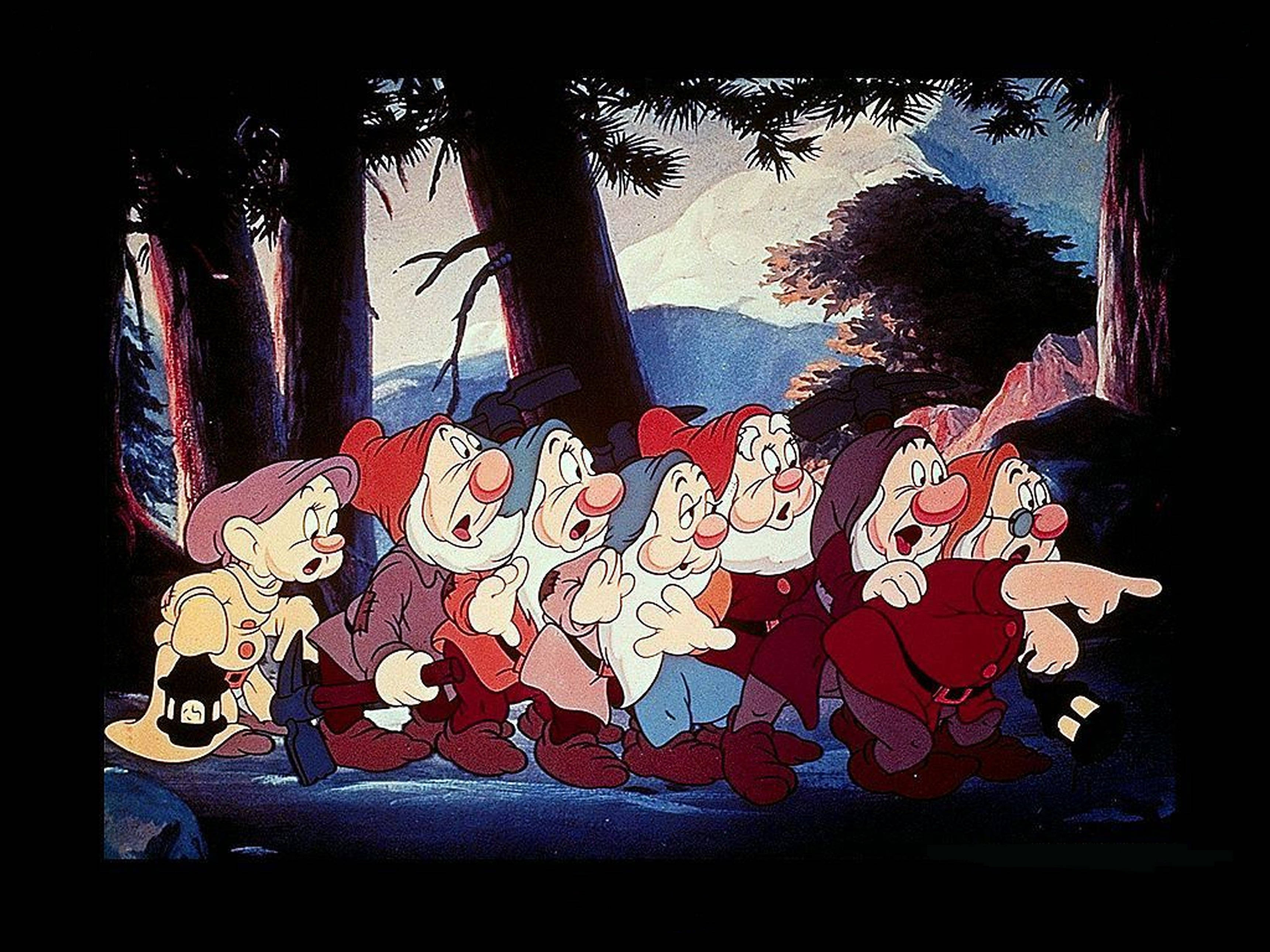 Seven Dwarfs 桌布 壁紙 — 七個經典卡通小矮人戴著紅帽子和穿著不搭配的衣服，站在森林空地上興奮地指向地平線。