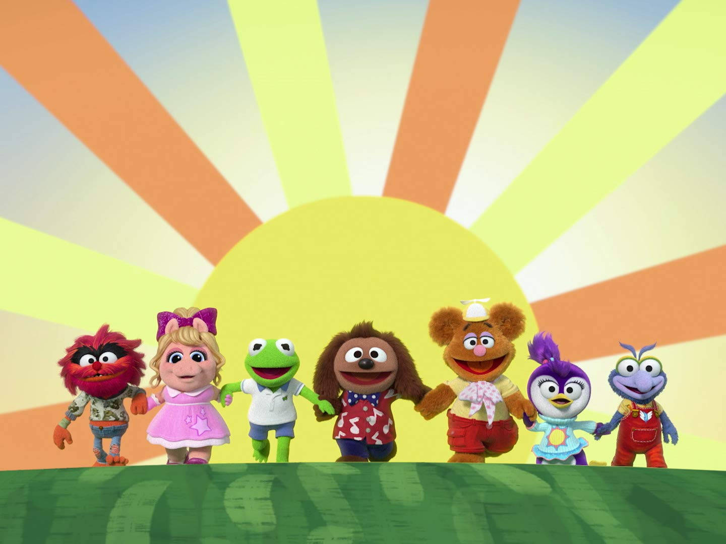 babies 桌布 壁紙 — 七個色彩繽紛的Muppet角色手牽手站在綠色草地上，背景是充滿活力的太陽光線。