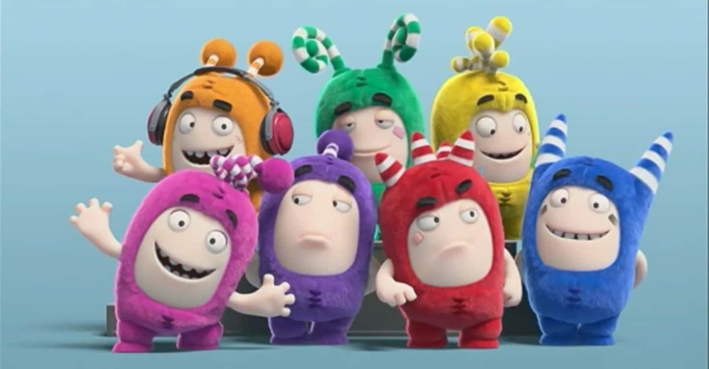 Oddbods 桌布 壁紙 — 七個色彩繽紛的卡通怪物，戴著獨特的帽子和表情，在純藍色背景前愉快地擺姿勢。
