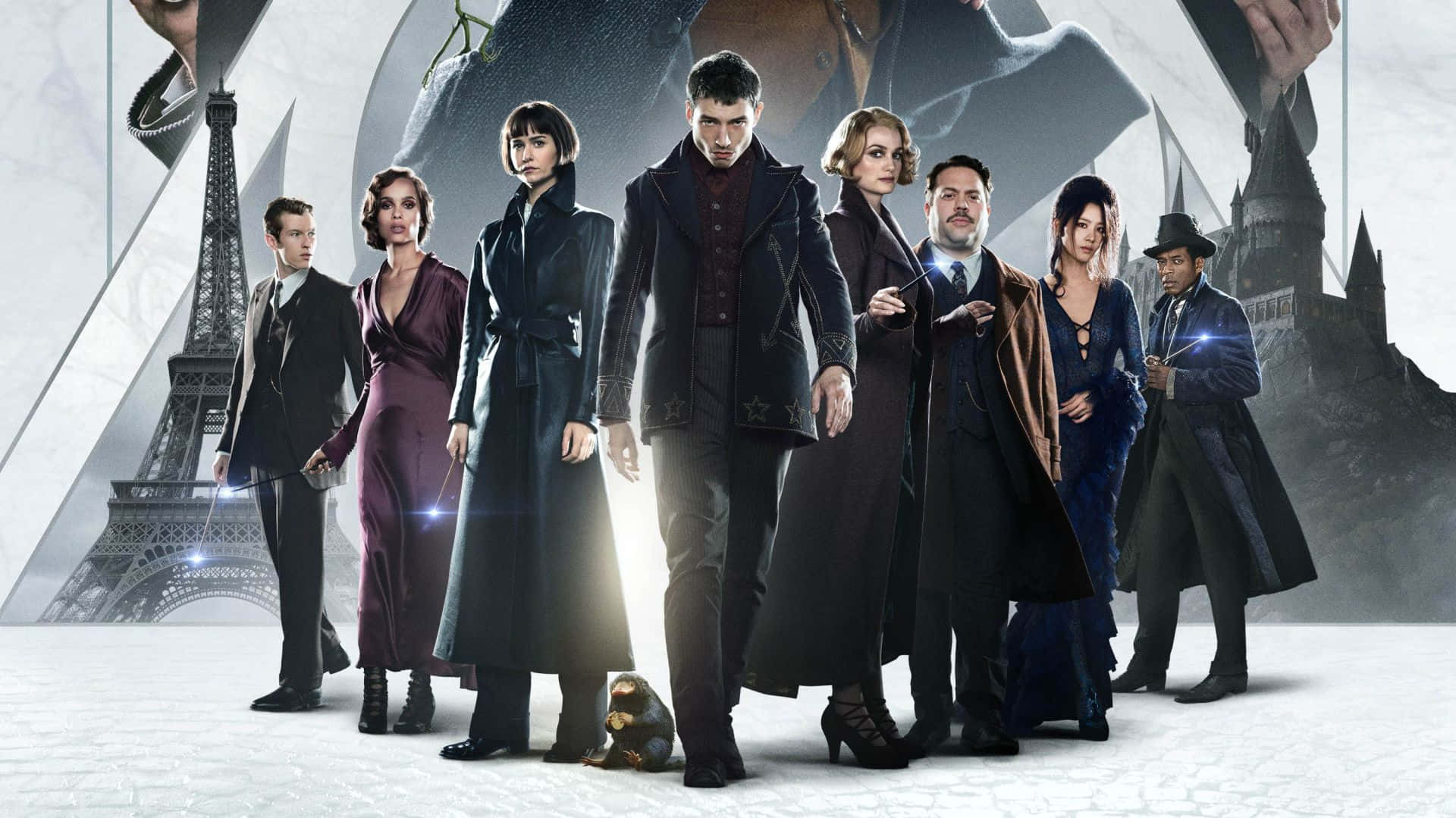Fantastic Beasts 桌布 壁紙 — 七個身穿深色正裝的角色自信地站在以艾菲爾鐵塔和霍格華茲城堡為背景的場景前。