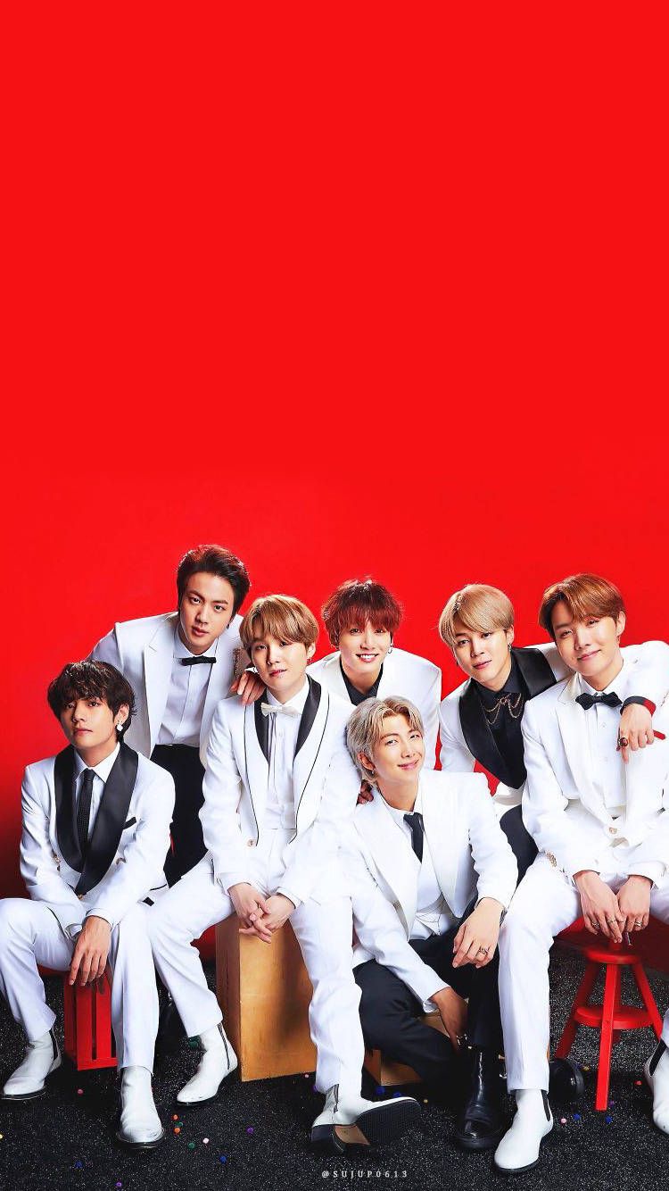 bts photoshoot 桌布 壁紙 — 七名身穿白色禮服的男士在鮮紅色背景前自信地擺姿勢，背景散落著五彩紙屑。