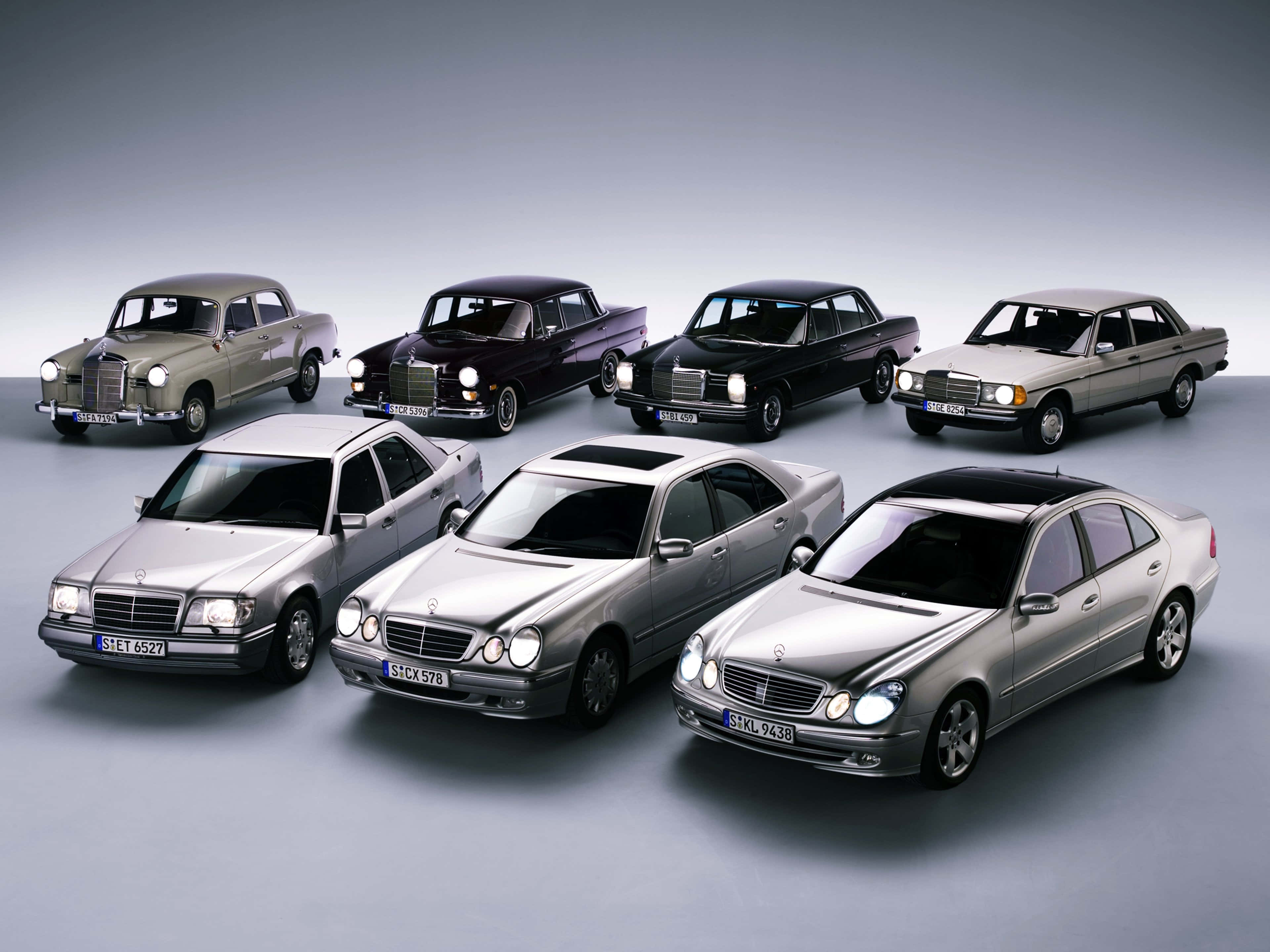 German 桌布 壁紙 — 七輛經典 Mercedes-Benz 房車，銀色、黑色和米色，在漸變灰色背景的攝影棚網格中排列。