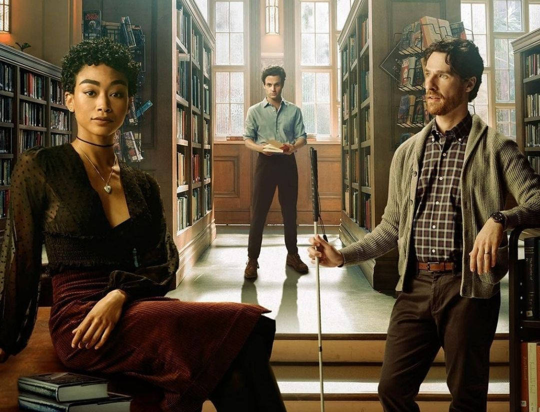 Netflix 桌布 壁紙 — 三人在陽光充足的圖書館內，有高書架，一人坐著，一人站著拿著書，一人拿著手杖。