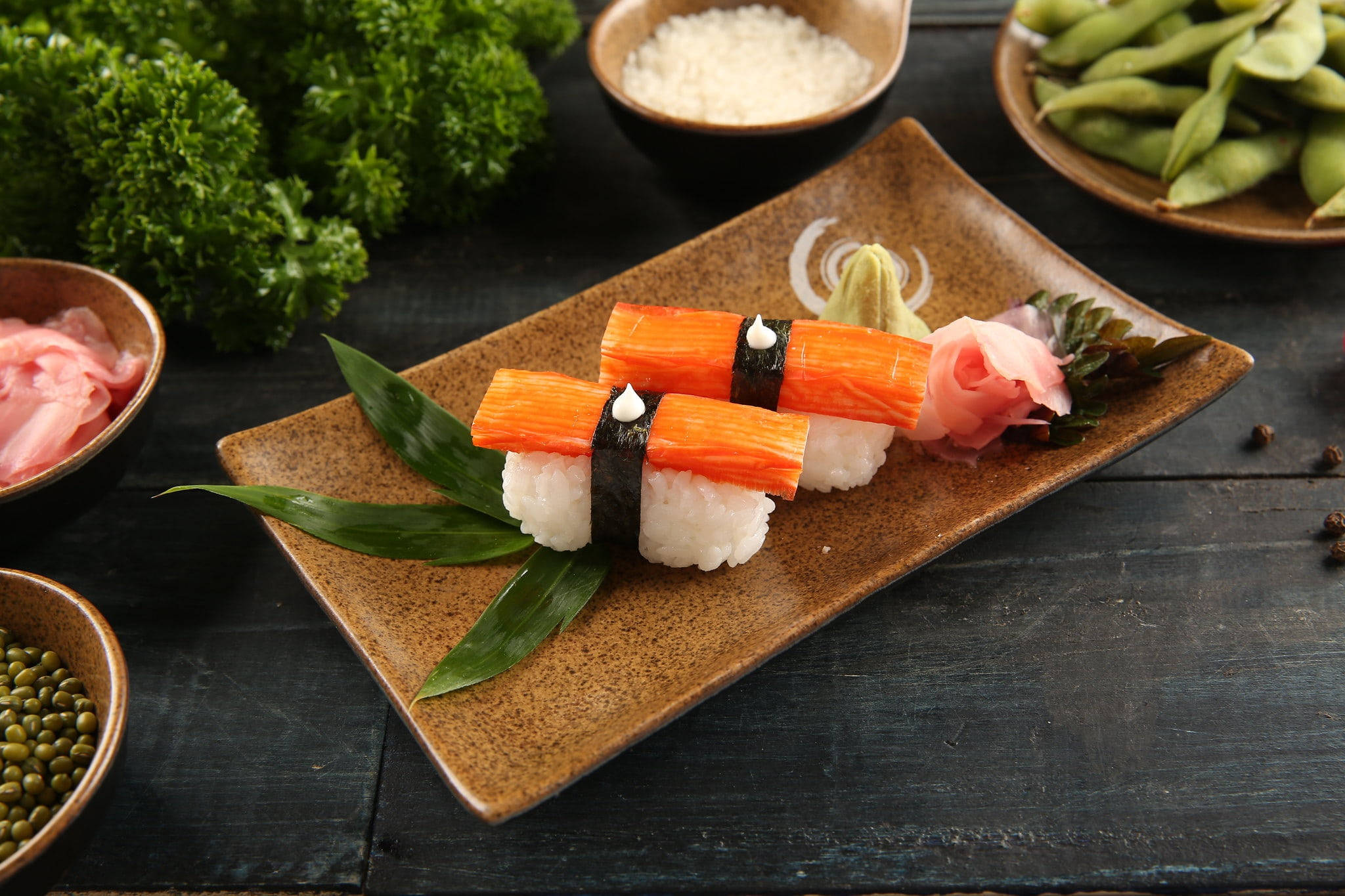 Sushi 桌布 壁紙 — 三件蟹棒壽司優雅地擺放在質樸的陶瓷盤上，配以裝飾和配菜。