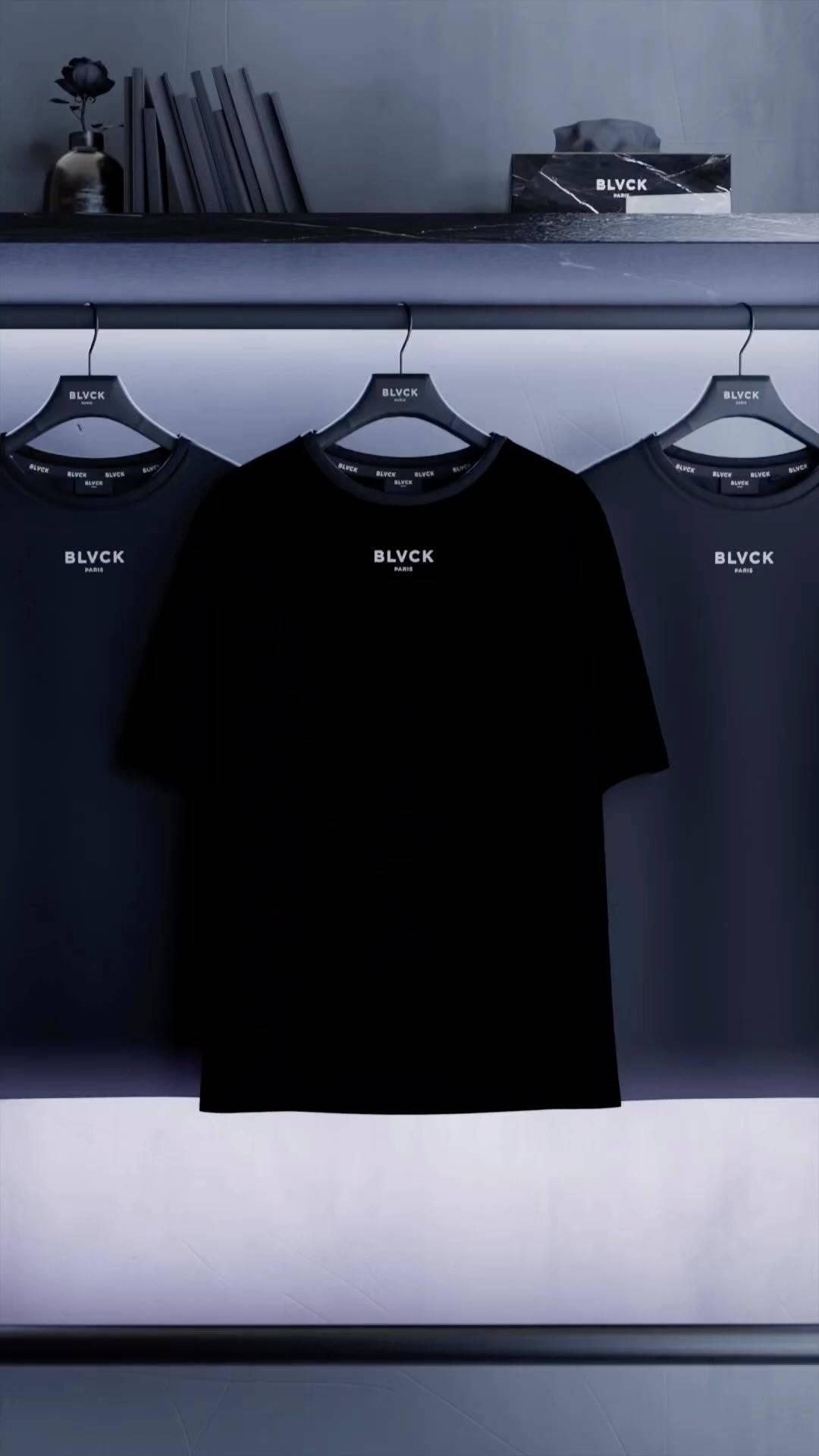 Blvck Paris 桌布 壁紙 — 三件黑色BLVCK T恤整齊地掛在極簡風格的衣架上，柔和藍色燈光下。