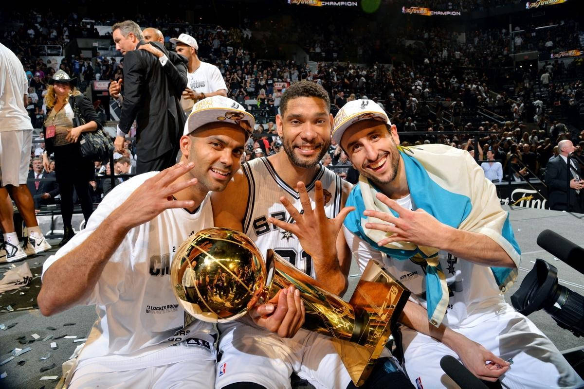 Tony Parker 桌布 壁紙 — 三位勝利的籃球運動員在擠滿觀眾的場館中，在五彩紙屑中慶祝冠軍獎盃。