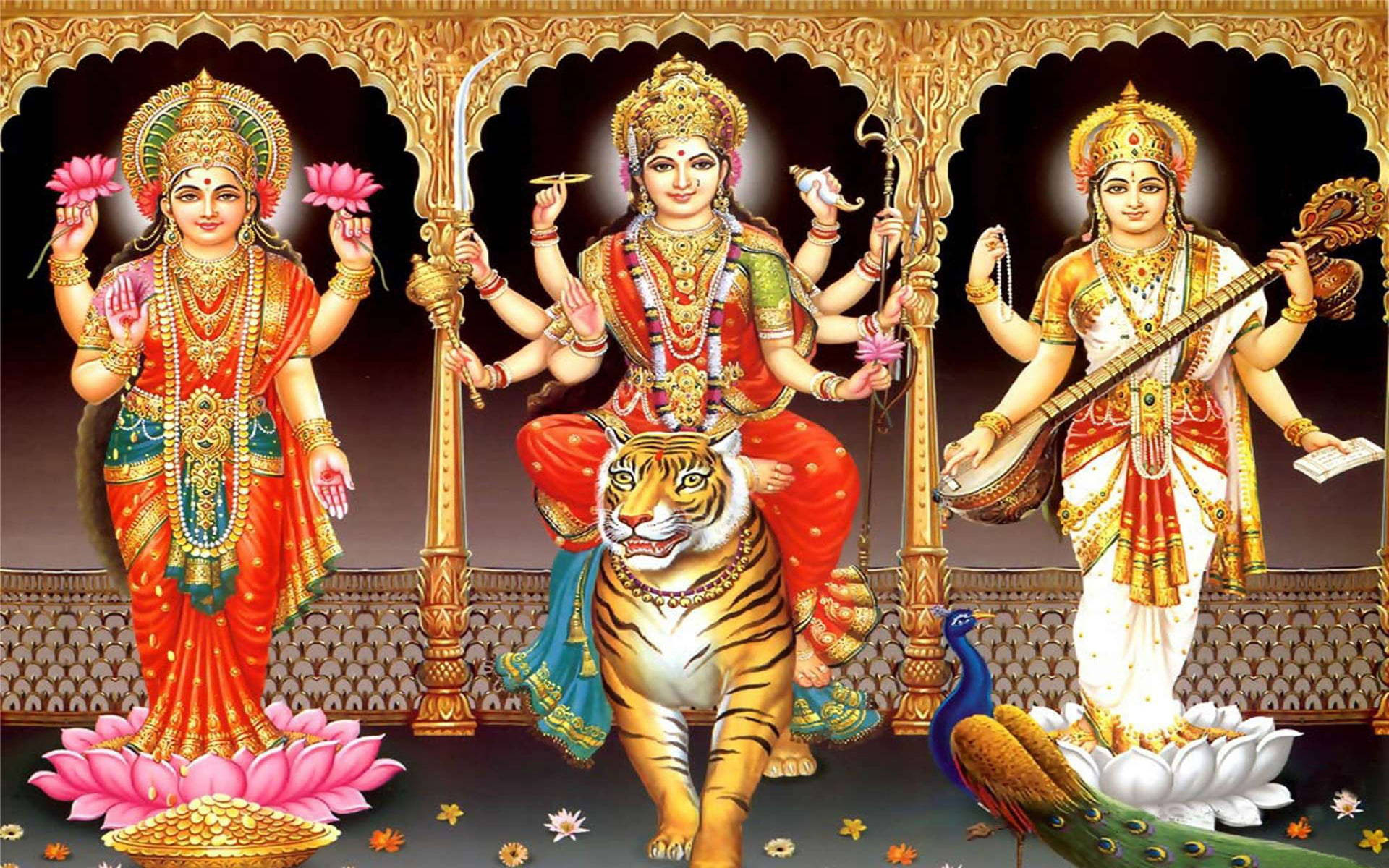 laxmi ganesh saraswati 桌布 壁紙 — 三位印度教女神佩戴鮮豔珠寶和色彩繽紛的服飾，優雅地站在華麗拱門下，腳邊有一隻老虎和一隻孔雀。