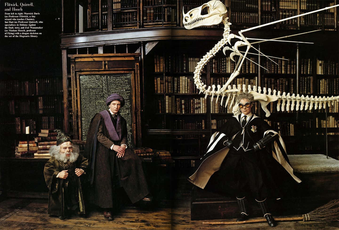 The Hogwarts Library 桌布 壁紙 — 三位巫師教授在霍格華茲圖書館，在溫暖燈光下站在龍骨和古籍旁邊擺姿勢。