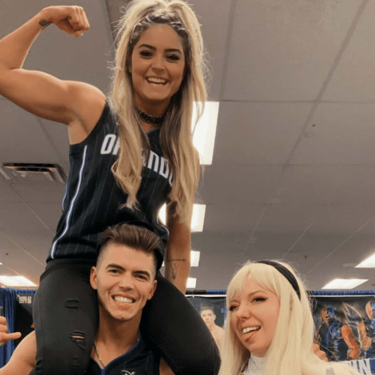 Wrestling 桌布 壁紙 — 三位微笑的啦啦隊員在室內擺姿勢，其中一位坐在另一位的肩膀上展示肌肉。