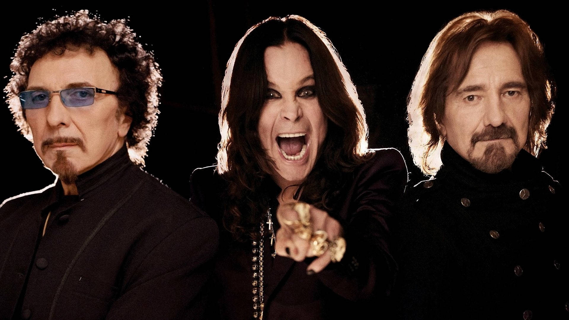 Ozzy Osbourne 桌布 壁紙 — 三位搖滾音樂家在黑色背景前以強烈的表情和深色服裝戲劇性地擺姿勢。