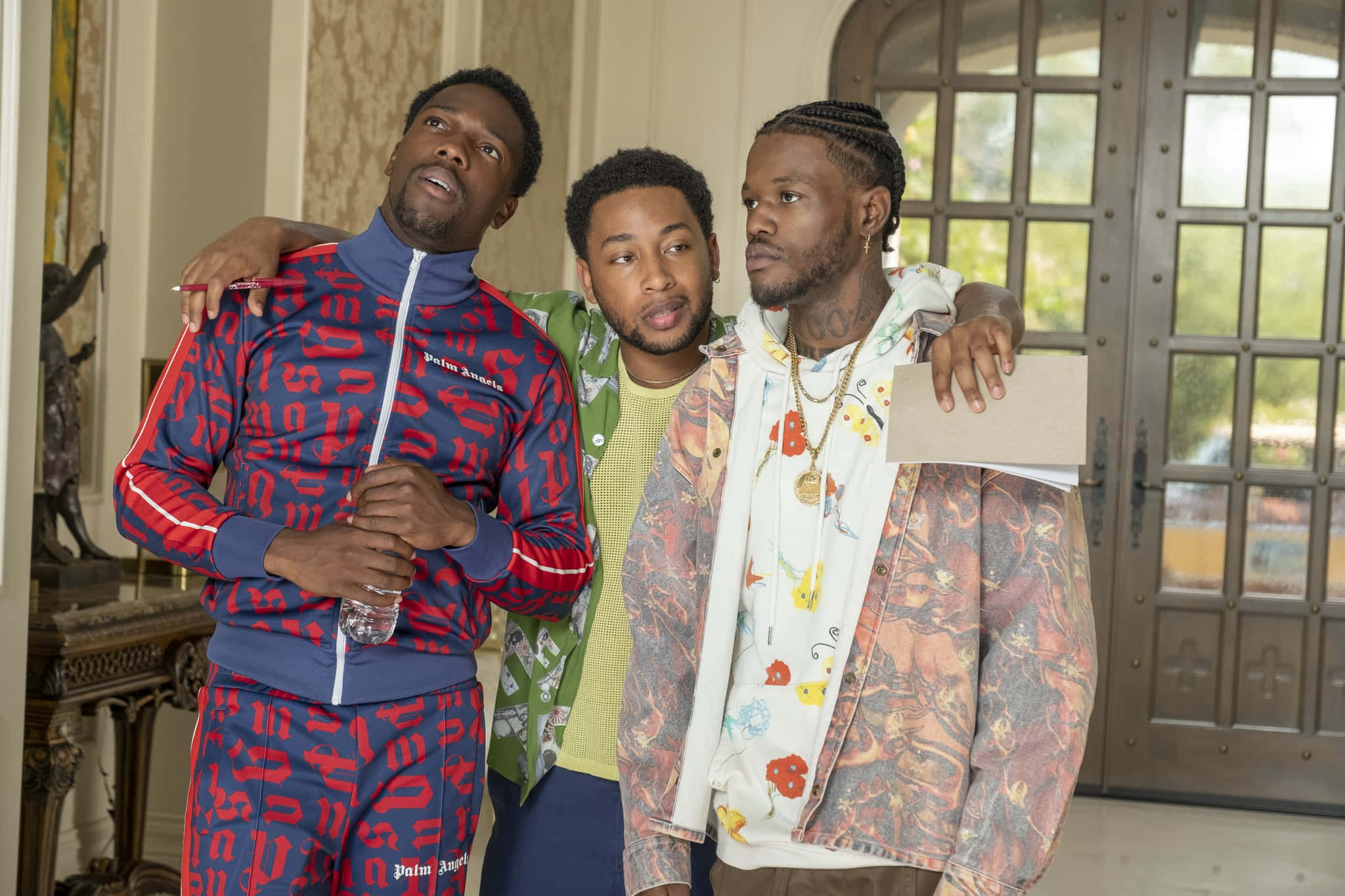 House Party 桌布 壁紙 — 三位時尚男士穿著大膽圖案服裝，在一個陽光充足、裝飾華麗且有大窗戶的房間裡一起擺姿勢。