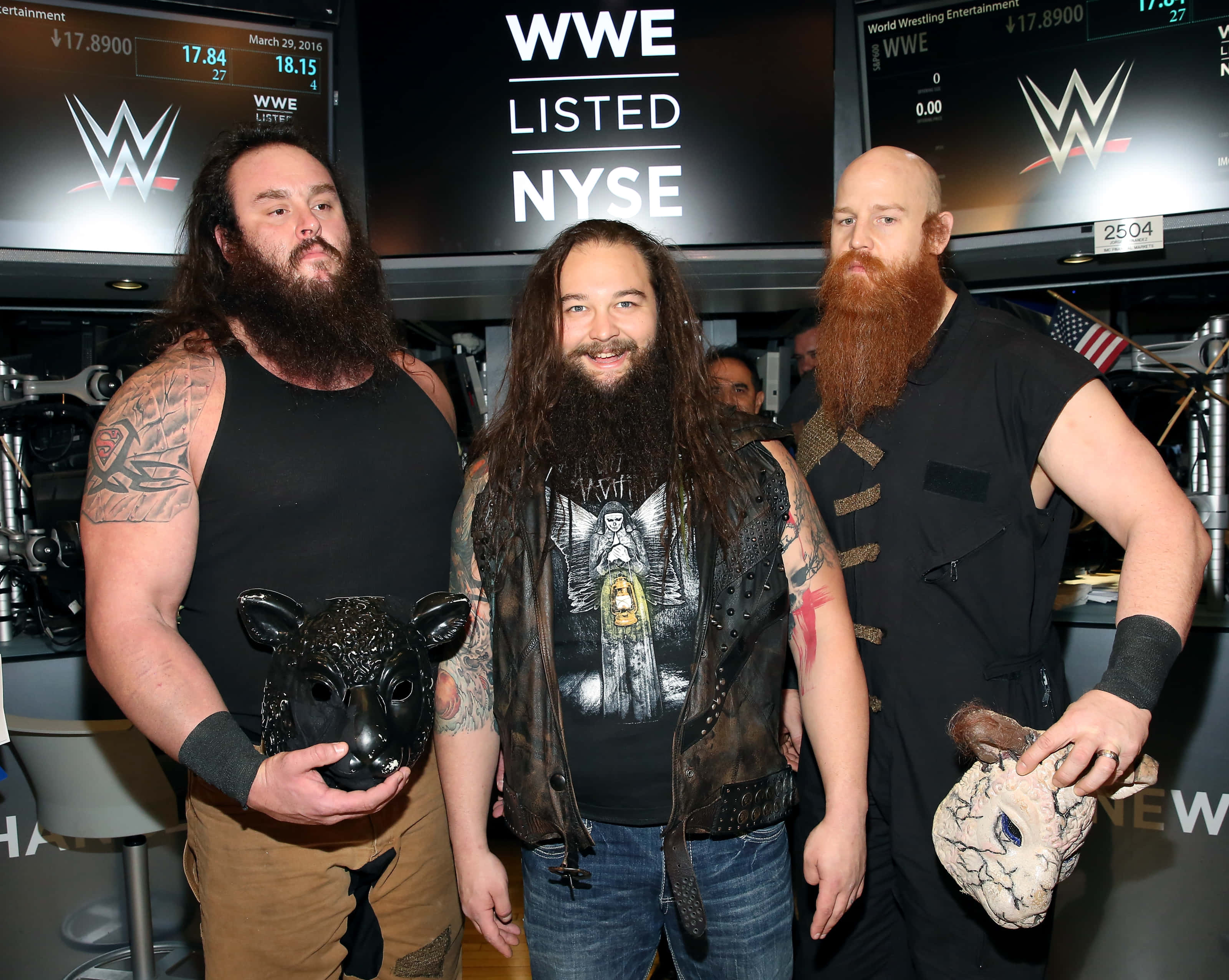 WWE 桌布 壁紙 — 三位留鬍鬚的WWE摔角手在發光屏幕下的NYSE上市儀式中戴著動物面具擺姿勢。