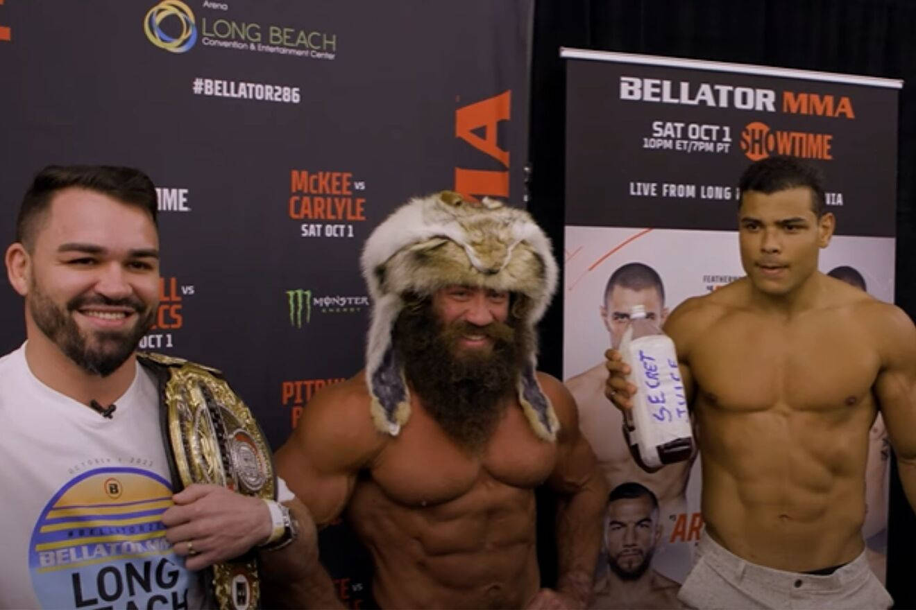 UFC 桌布 壁紙 — 三位肌肉發達的MMA拳手在Bellator活動中擺姿勢，一人戴著毛帽並拿著瓶子，另一人展示冠軍腰帶。