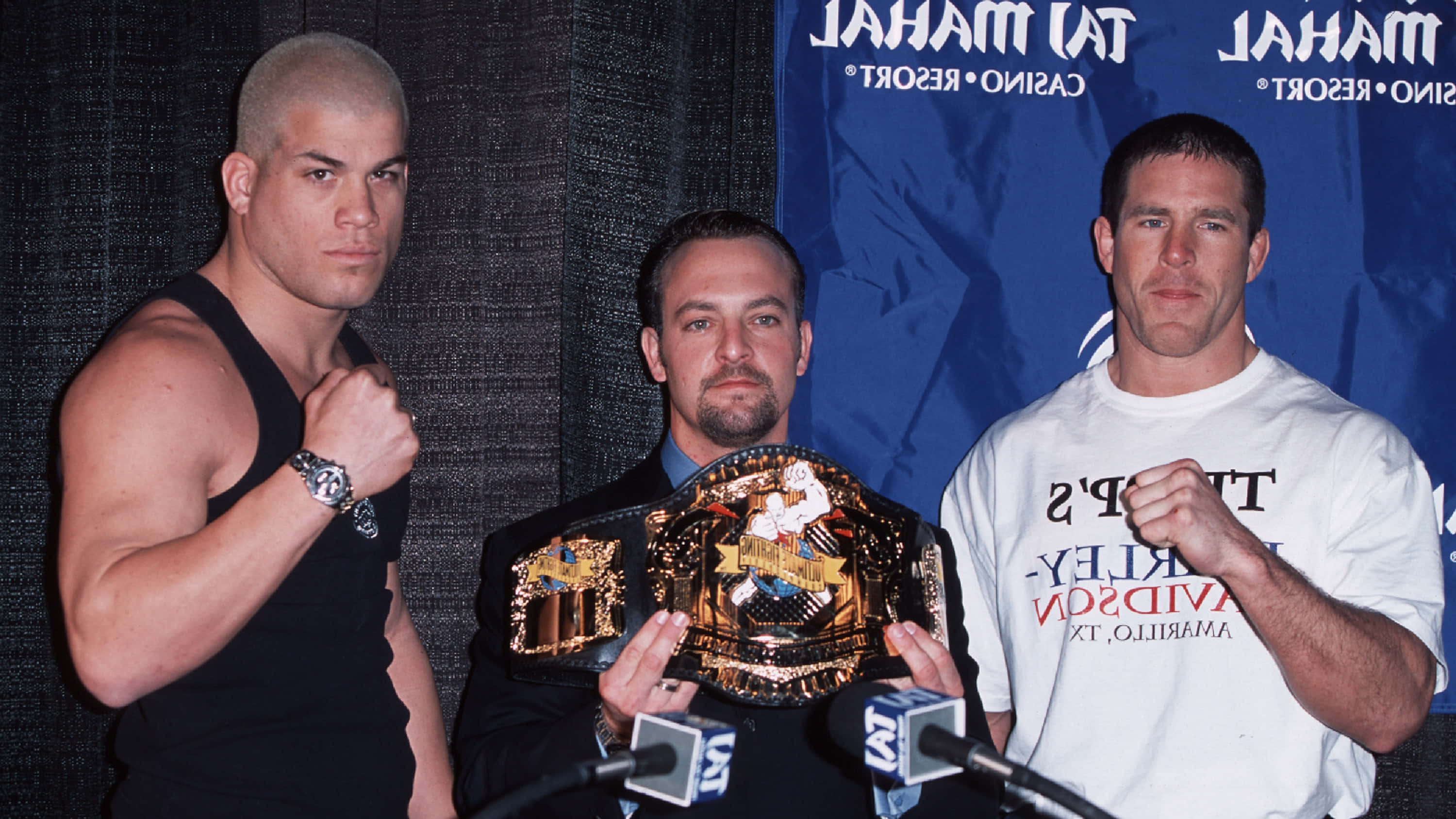 martial arts 桌布 壁紙 — 三位肌肉發達的男士在藍色賭場背景下的記者會上，拿著冠軍腰帶擺姿勢。