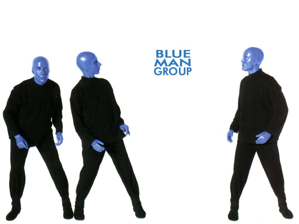 Blue Man Group 桌布 壁紙 — 三位藍臉表演者身穿黑色服裝，在純白色背景前擺姿勢，背景上有'BLUE MAN GROUP'字樣。