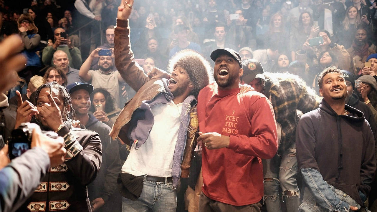 Kanye 桌布 壁紙 — 三位說唱歌手在煙霧瀰漫的人群中於舞台上慶祝，粉絲們用手機記錄這一刻。
