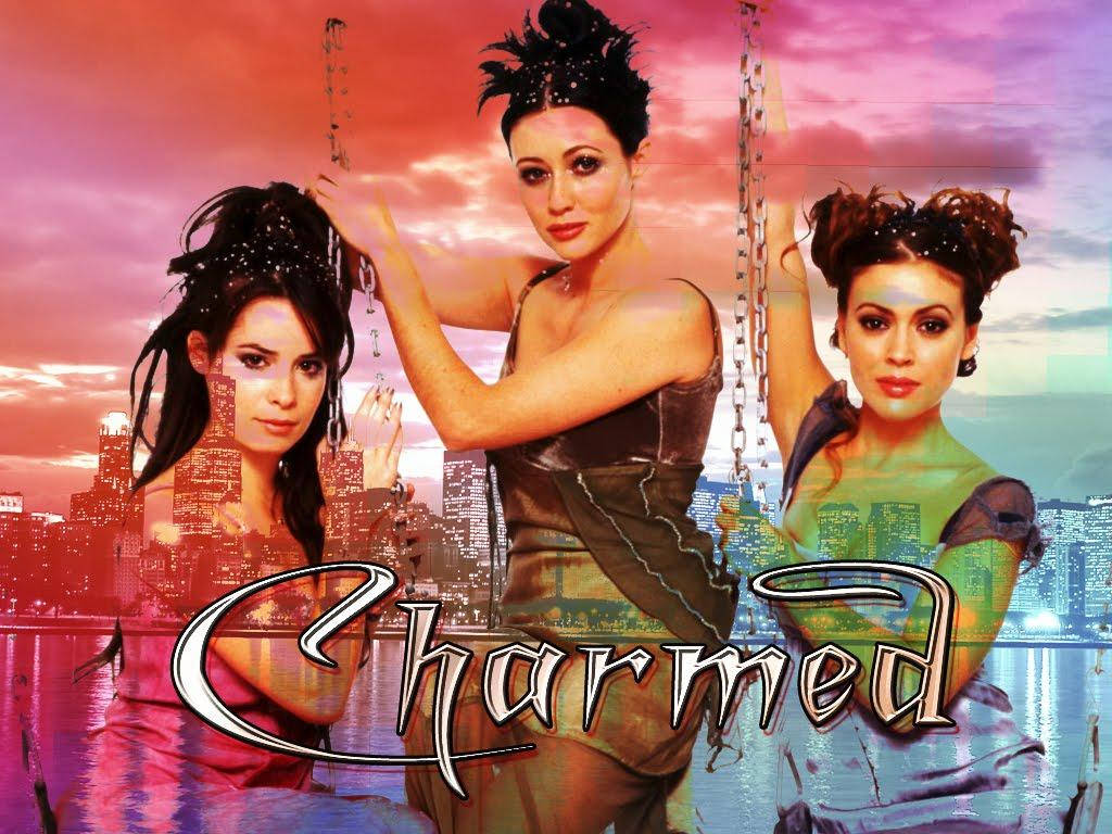 charmed 桌布 壁紙 — 三位身穿女巫服飾的女性在日落時分漂浮在城市天際線上方，伴隨著鎖鏈和以風格化字體呈現的「Charmed」字樣。
