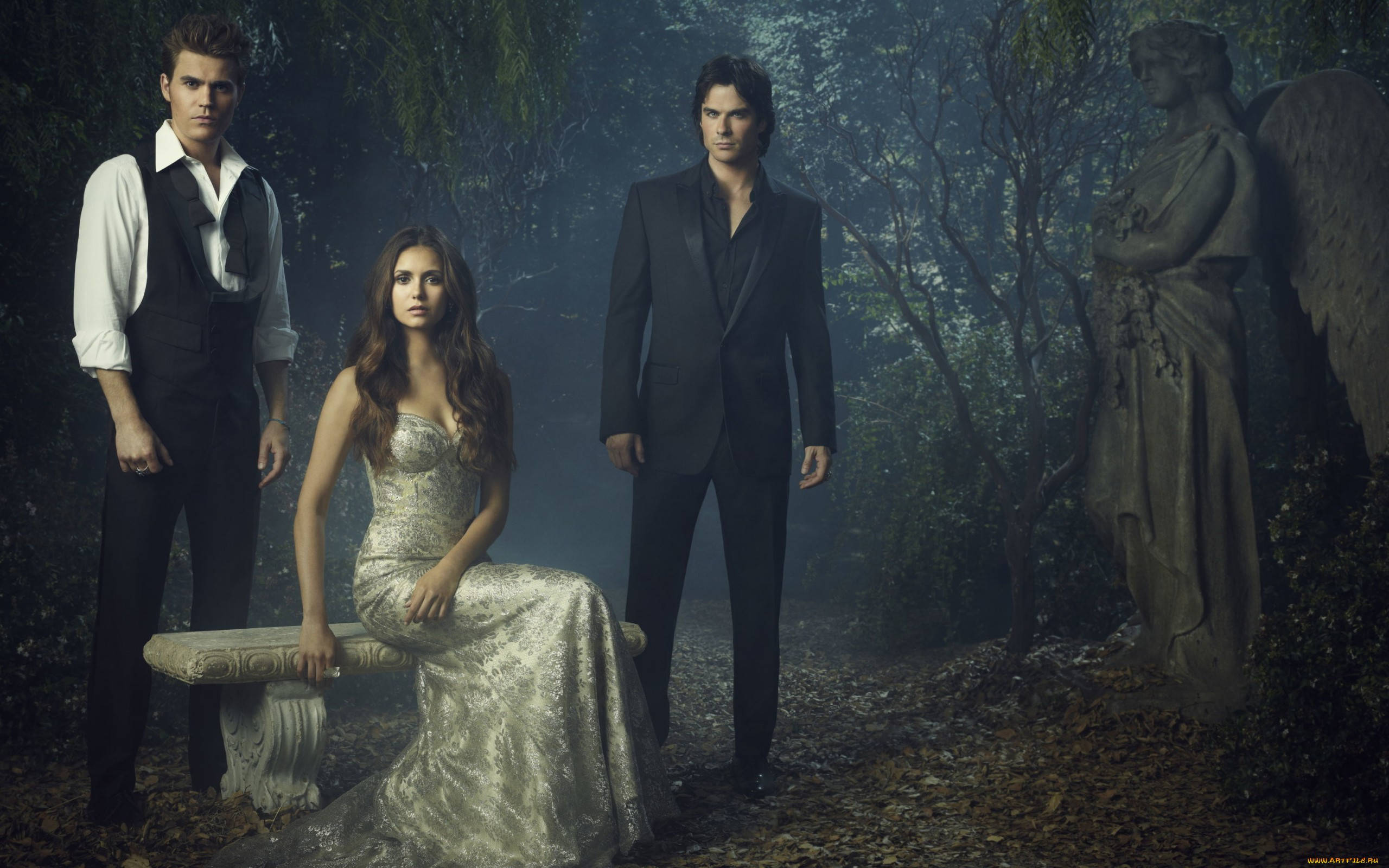 The Vampire Diaries 桌布 壁紙 — 三位身穿正裝的人物站在迷霧森林中，旁邊有一張石凳和天使雕像。