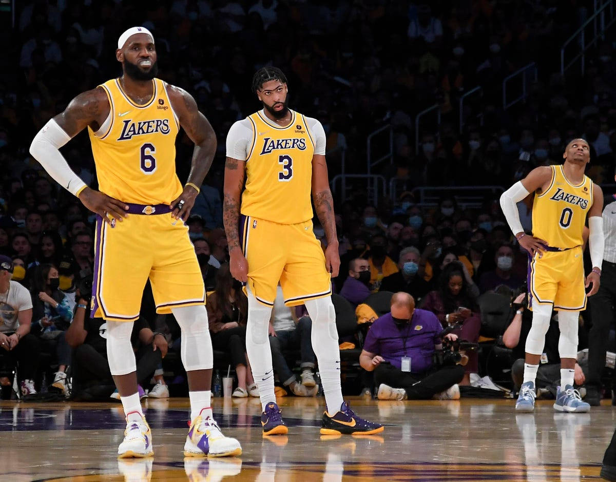 NBA 桌布 壁紙 — 三位身穿黃色球衣的湖人籃球運動員站在拋光球場上，背景是戴著口罩的人群。