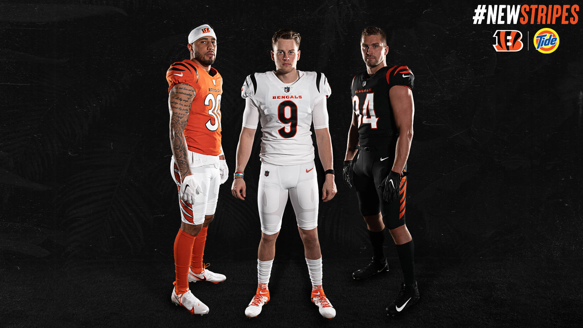 Bengals 桌布 壁紙 — 三位辛辛那提猛虎隊美式足球員身穿全新橙色、黑色和白色球衣，在深色紋理背景前擺姿勢。