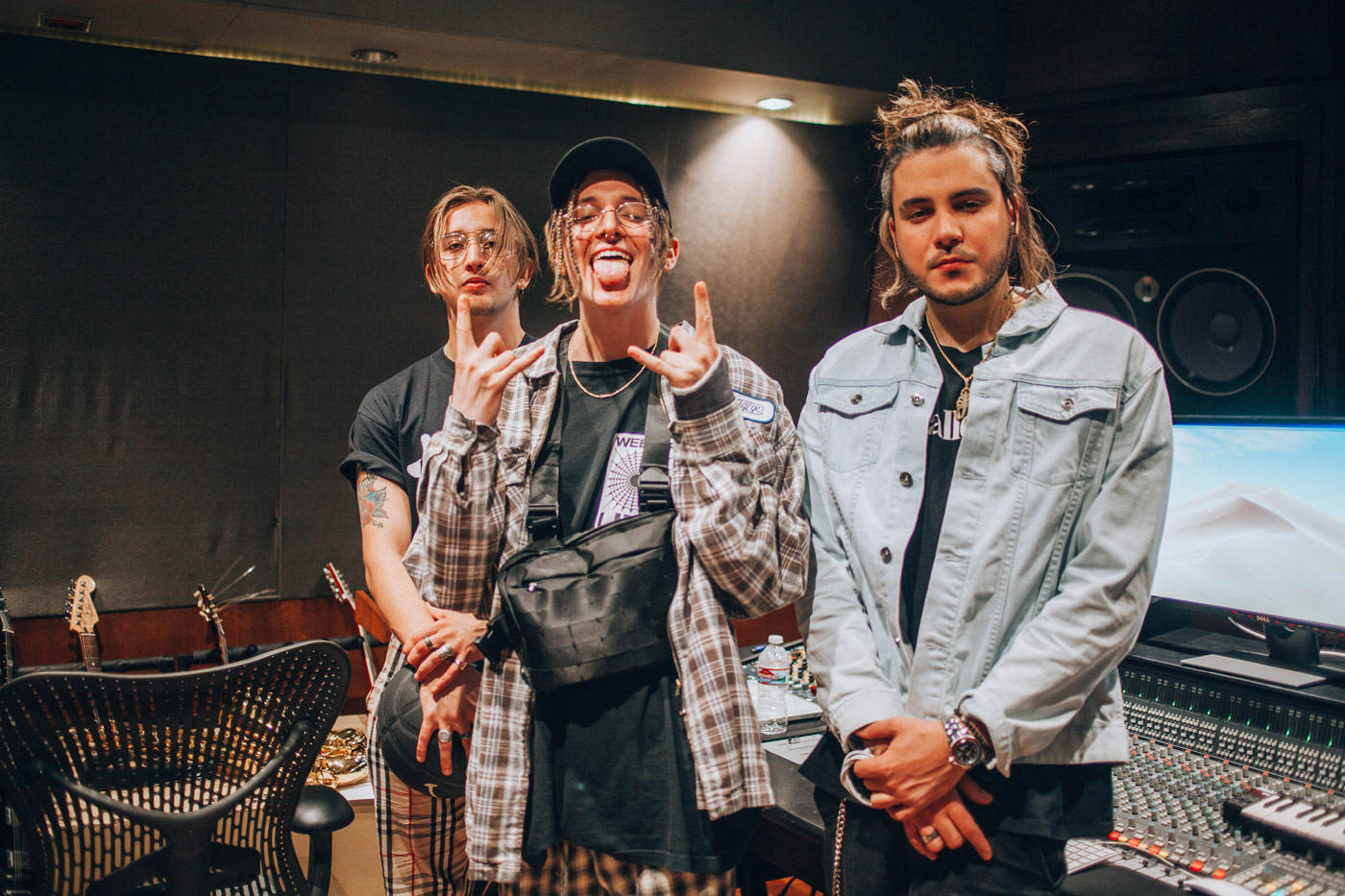Chase Atlantic 桌布 壁紙 — 三位音樂家在燈光昏暗的錄音室中俏皮地擺姿勢，周圍有音響設備和吉他。