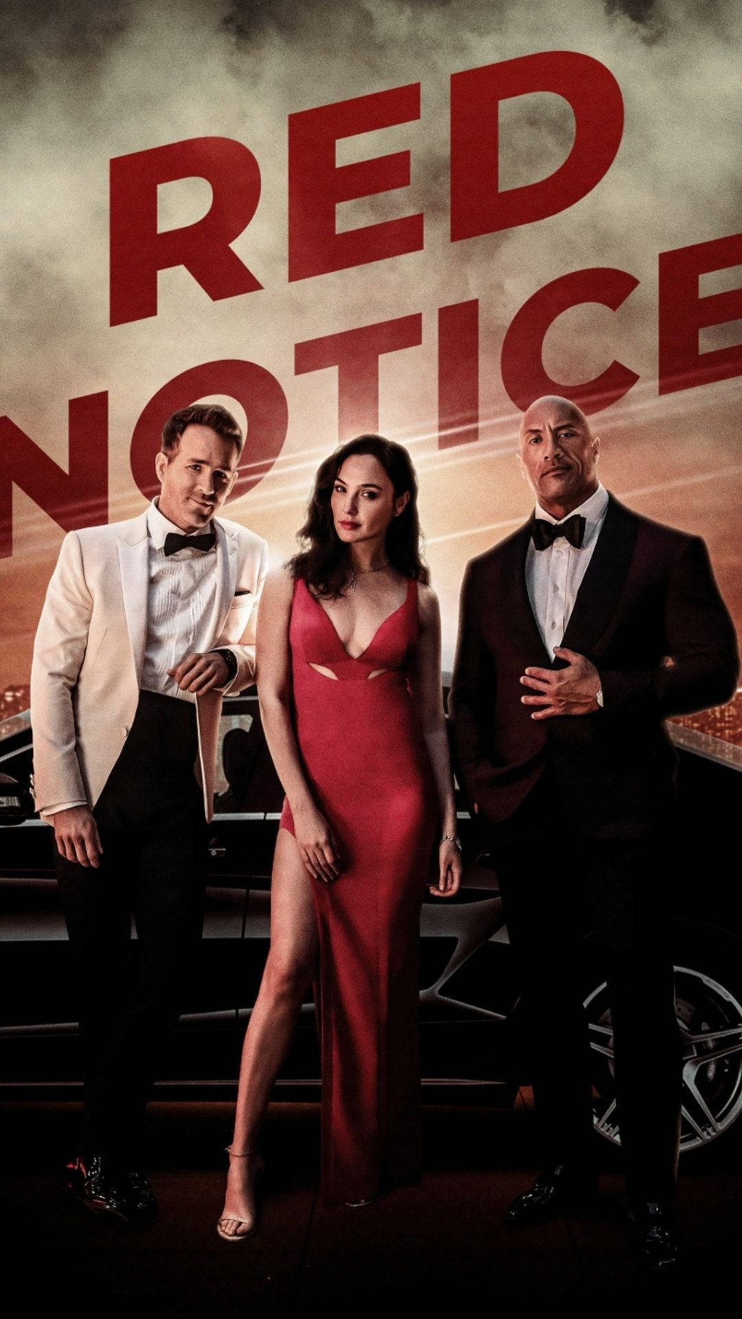 Notice 桌布 壁紙 — 三位魅力四射的演員身著正裝，站在一輛時尚汽車前，背景煙霧繚繞，上方有戲劇性的紅色文字寫著「RED NOTICE」。