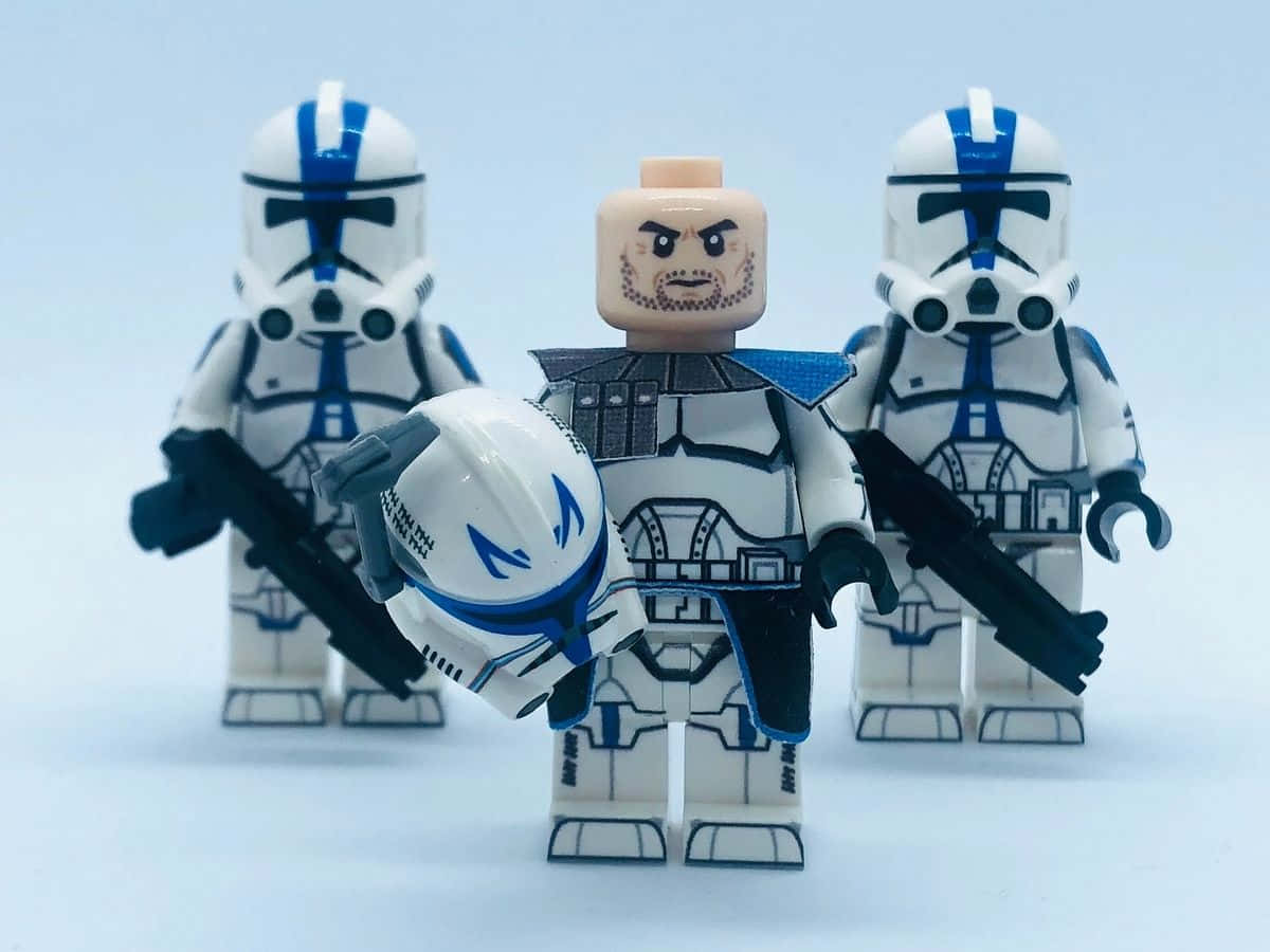 樂高 桌布 壁紙 — 三個LEGO星際大戰複製人士兵排成隊形，其中一個手持頭盔，背景為純白色。