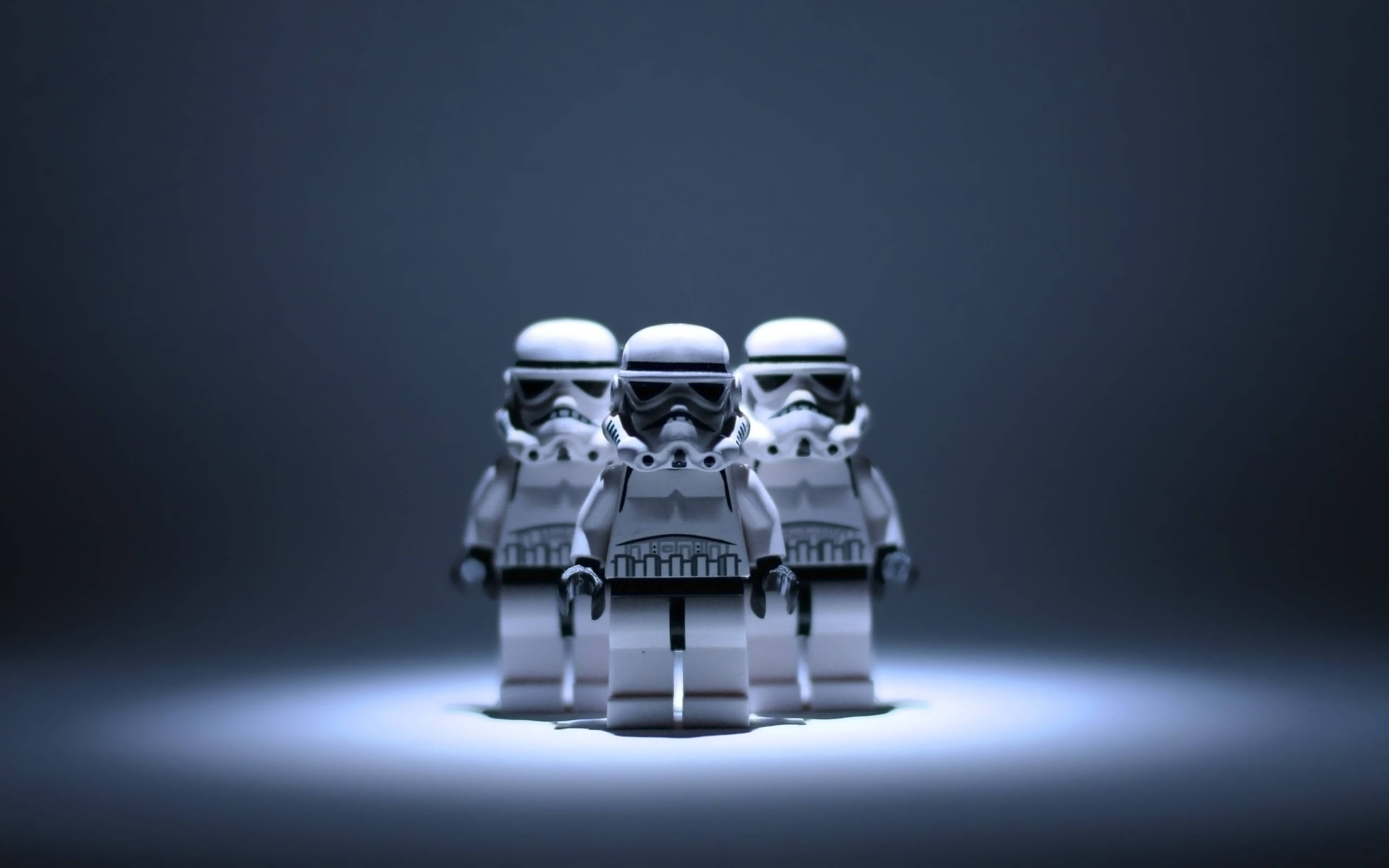 星際大戰 桌布 壁紙 — 三個LEGO風暴兵站在聚光燈下，背景為深色漸變，燈光效果戲劇化。