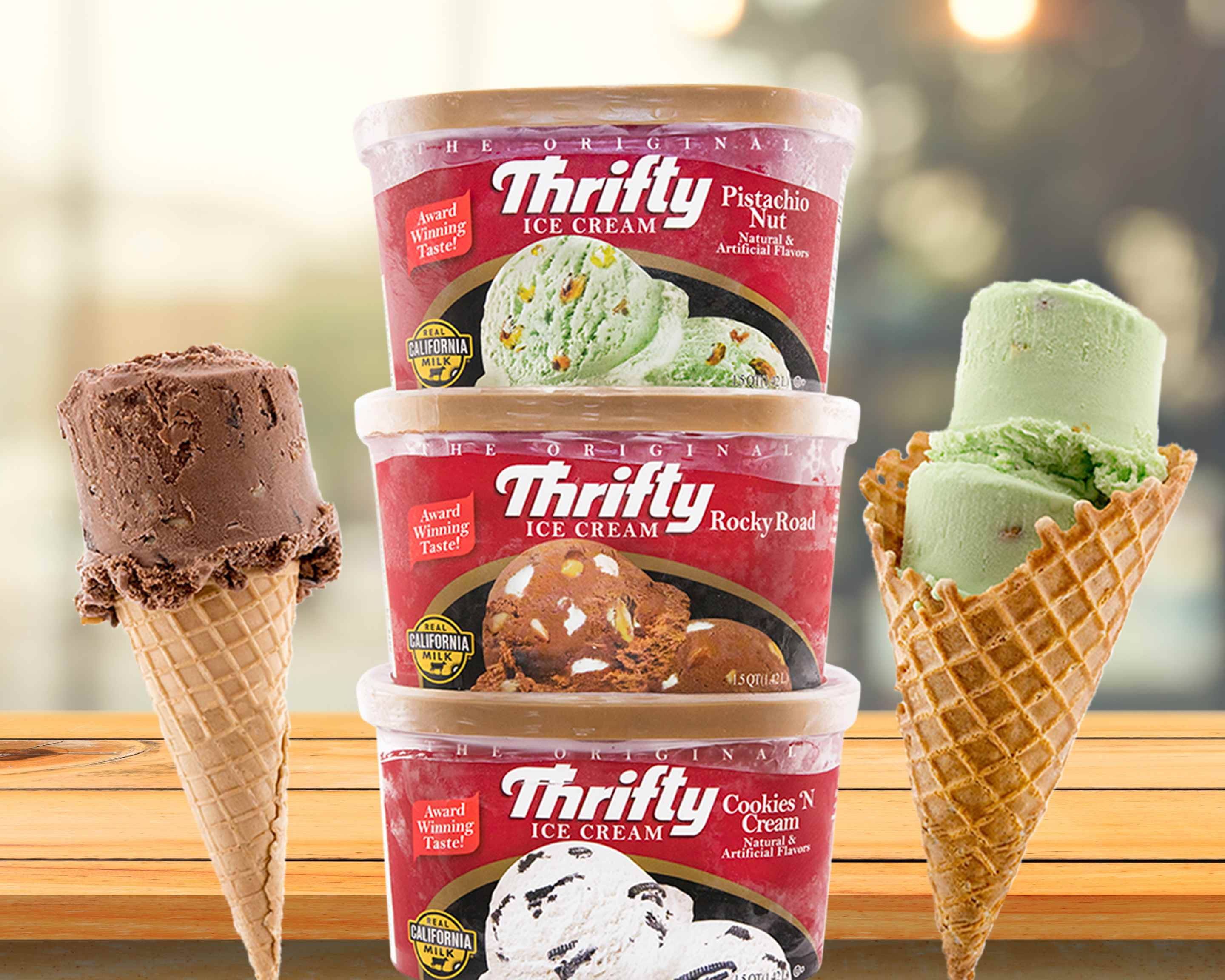 Ice Cream 桌布 壁紙 — 三個Thrifty冰淇淋桶疊起，旁邊有巧克力、開心果和餅乾奶油甜筒，放在木質表面上。
