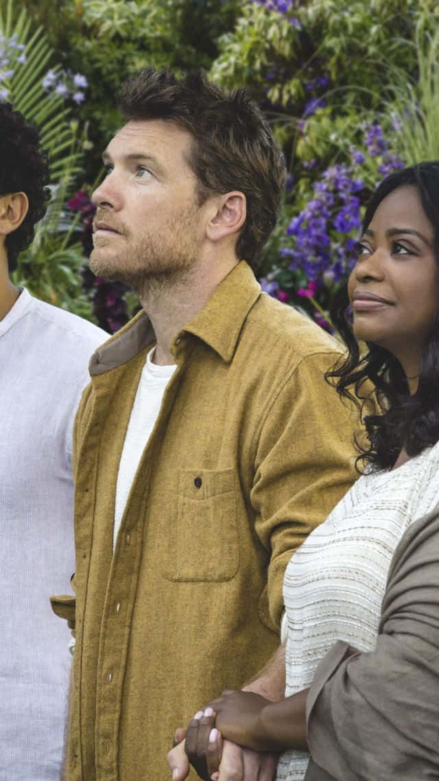 actor 桌布 壁紙 — 三個人一起站在一個長滿紫色花朵的茂盛花園中，抬頭仰望，表情若有所思。
