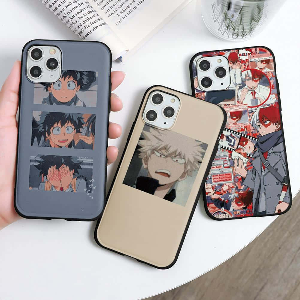Phone Case 桌布 壁紙 — 三個以《我的英雄學院》角色為主題的動漫風格手機殼，展示在白色桌子上，旁邊有一本書和一個玻璃杯。
