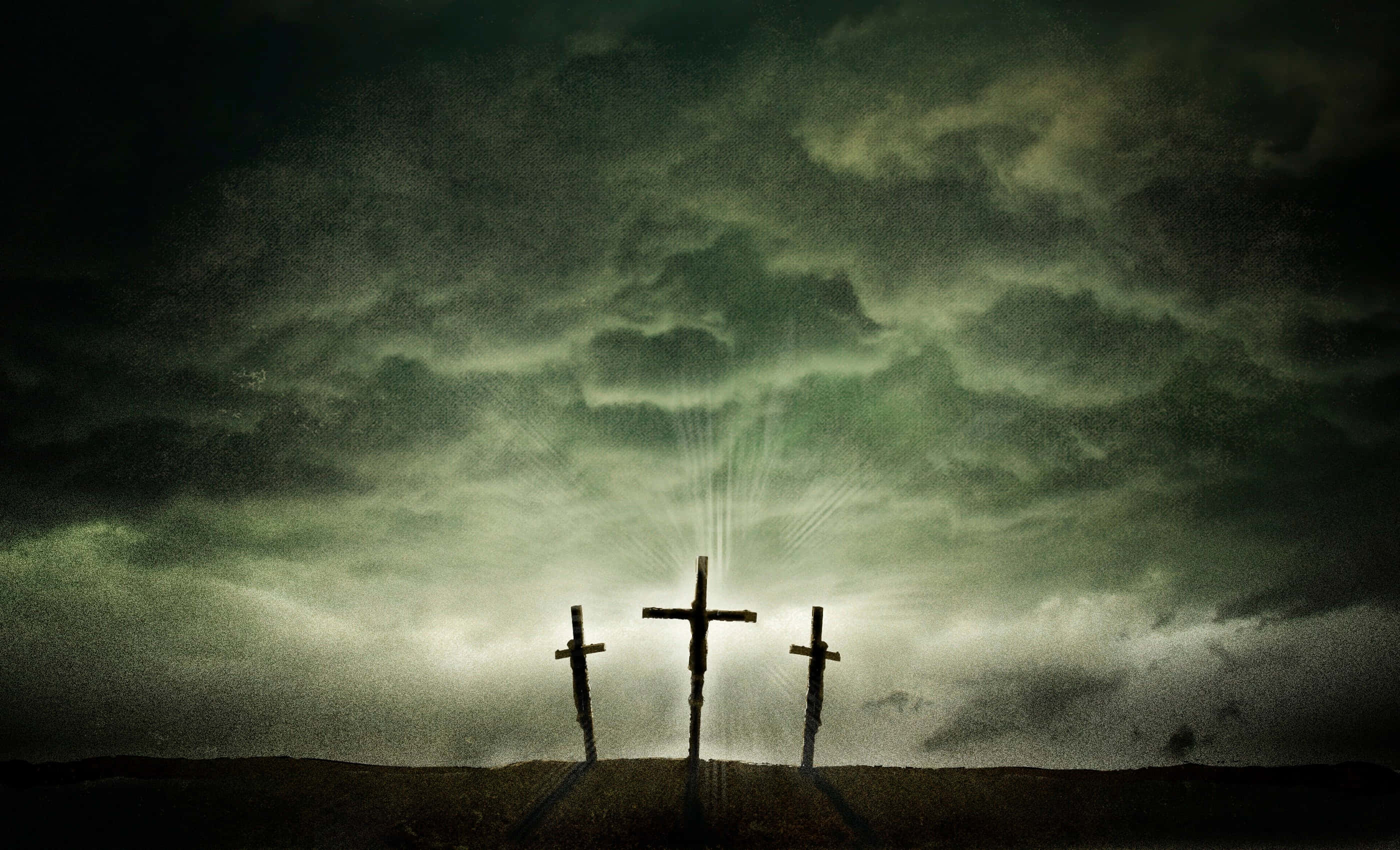 Catholic 桌布 壁紙 — 三個剪影十字架矗立在山丘上，暴風雨般的綠色天空下，中央十字架散發出耀眼的光芒。