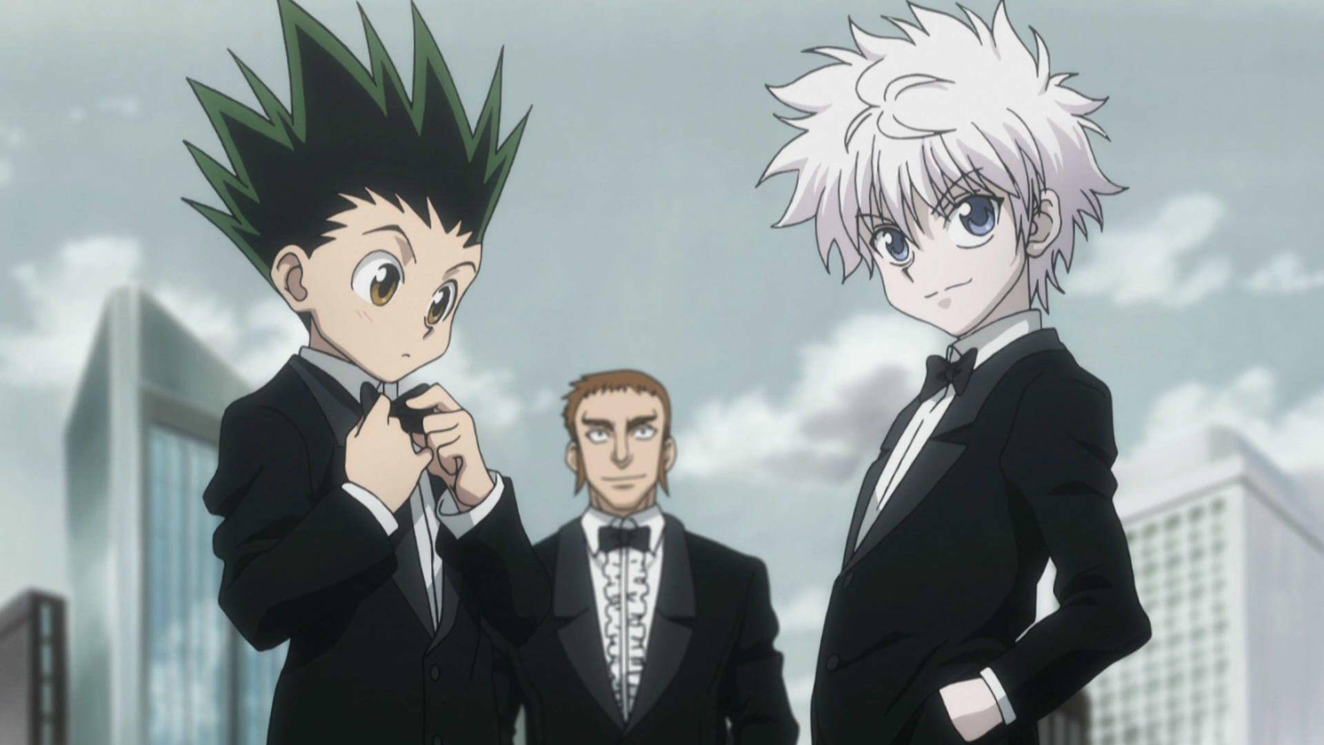 Gon And Killua 桌布 壁紙 — 三個動漫角色穿著正式黑色燕尾服，自信地站在多雲的城市天際線前。