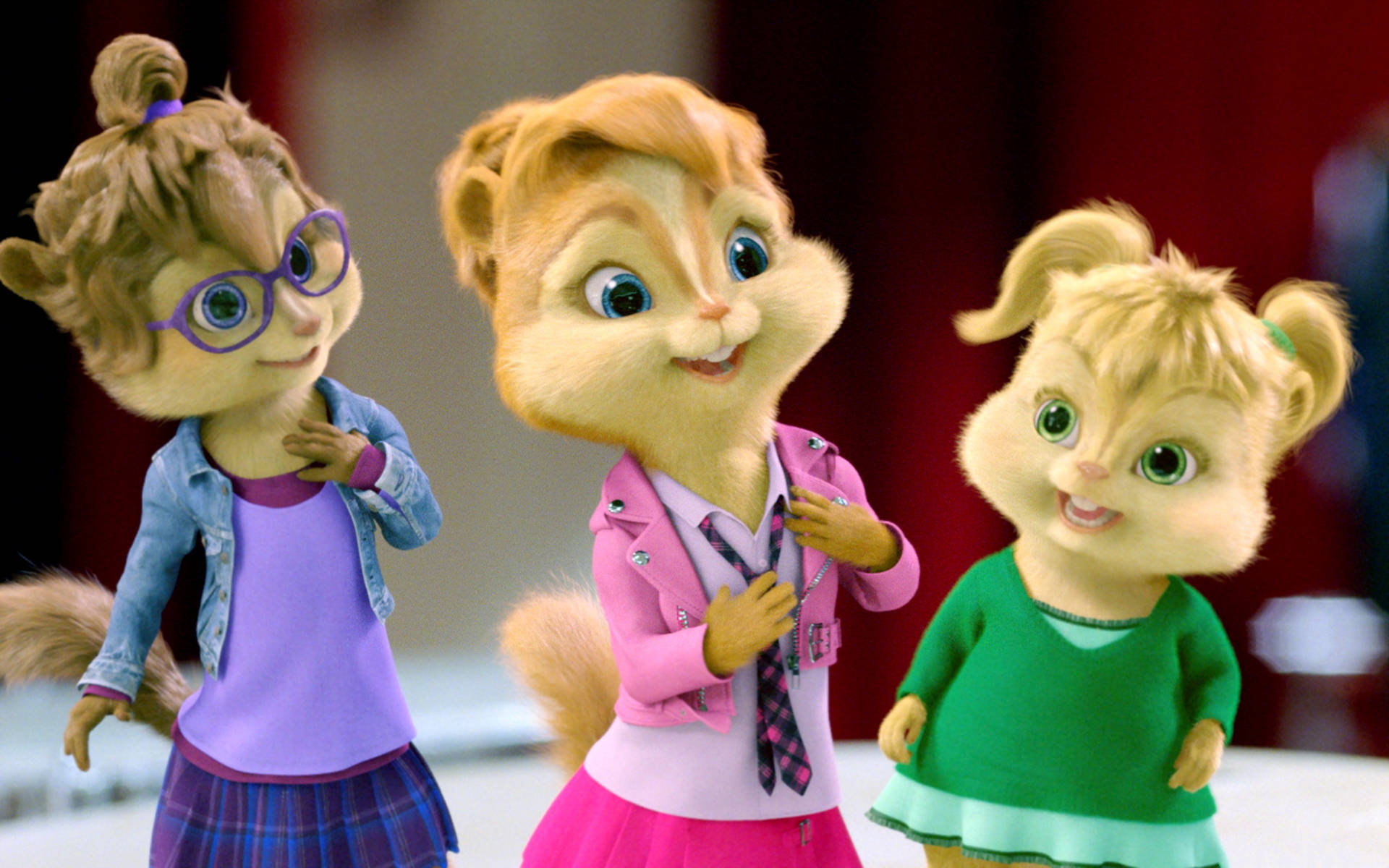 Chipmunks 桌布 壁紙 — 三個動畫花栗鼠女孩穿著色彩繽紛的服裝，對著鏡頭開心地微笑。