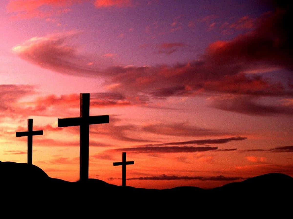 Cool Cross 桌布 壁紙 — 三個十字架在火紅的日落天空和漩渦狀雲彩的襯托下呈現剪影。