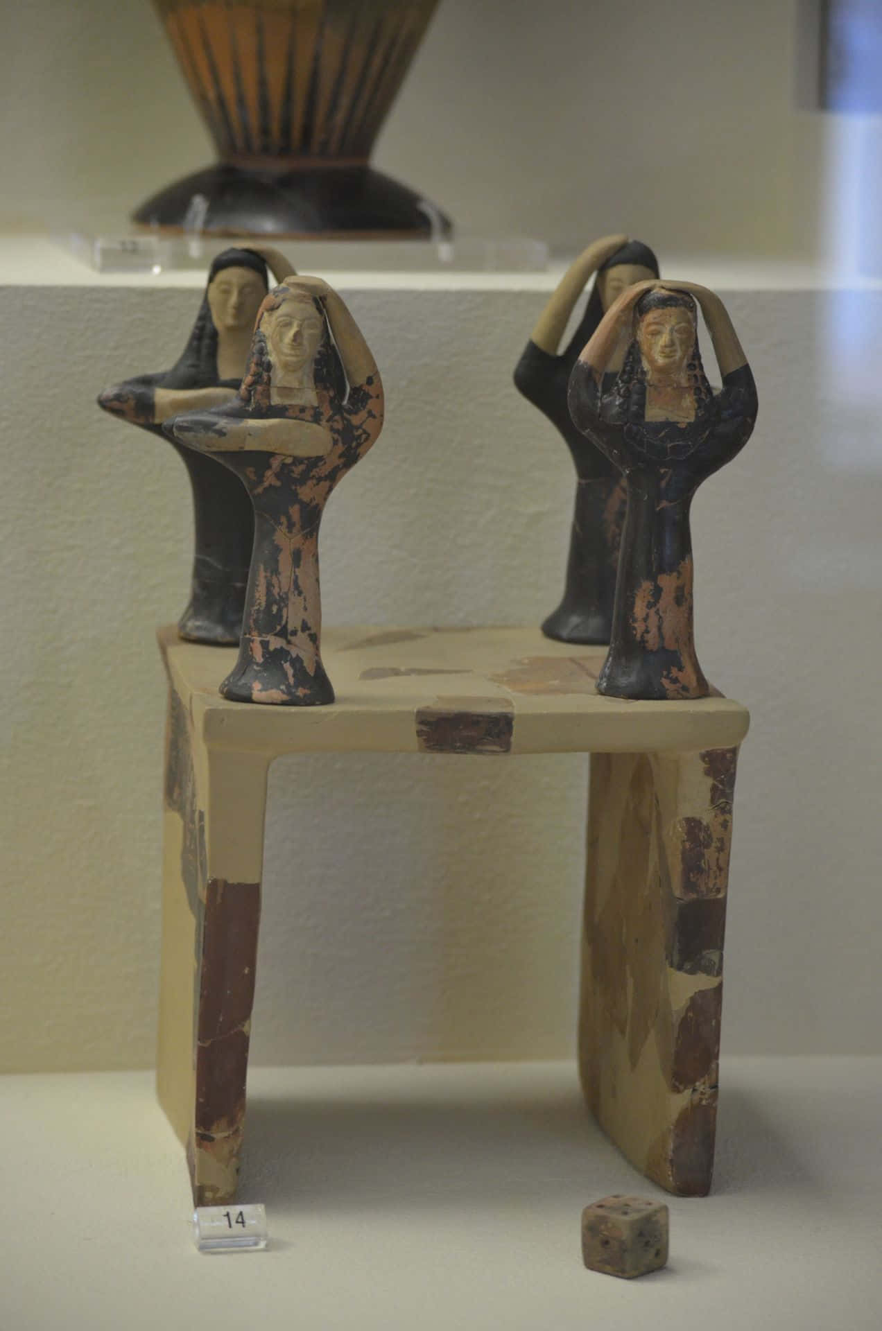 Mystical Artifacts 桌布 壁紙 — 三個古埃及小雕像舉起雙臂，站在博物館展示櫃內一張風化的木桌上。