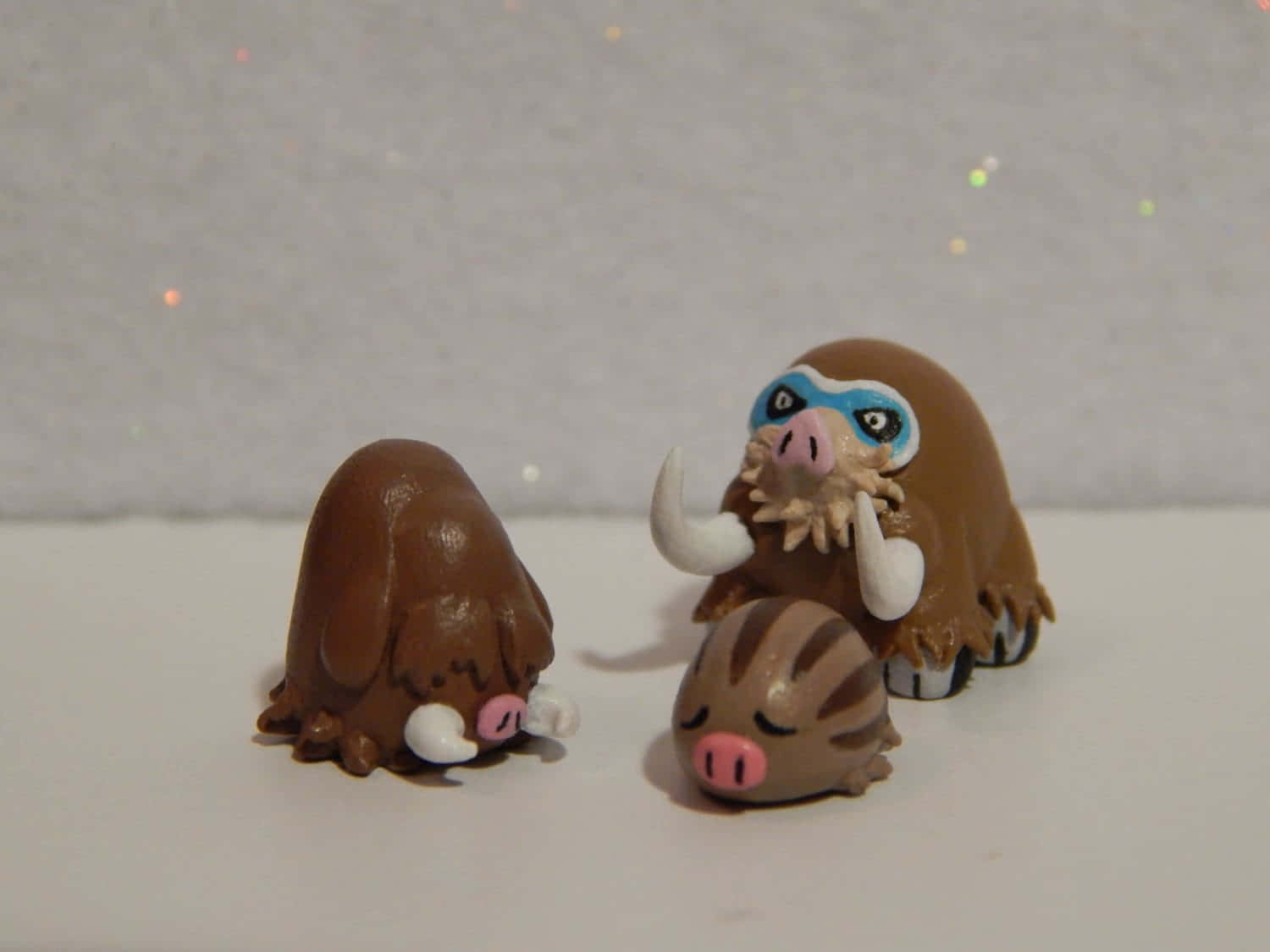 Pokemon Aesthetic 桌布 壁紙 — 三個可愛的手工黏土寶可夢公仔，分別是Bidoof、Bidoof和Bidoof，一起擺放在普通表面上，背景閃閃發光。