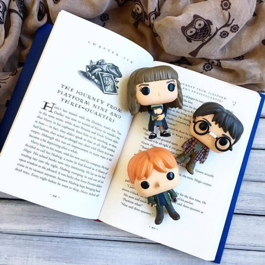 pop 桌布 壁紙 — 三個哈利波特 Funko Pop 公仔棲息在關於九又四分之三月台的打開書頁上。