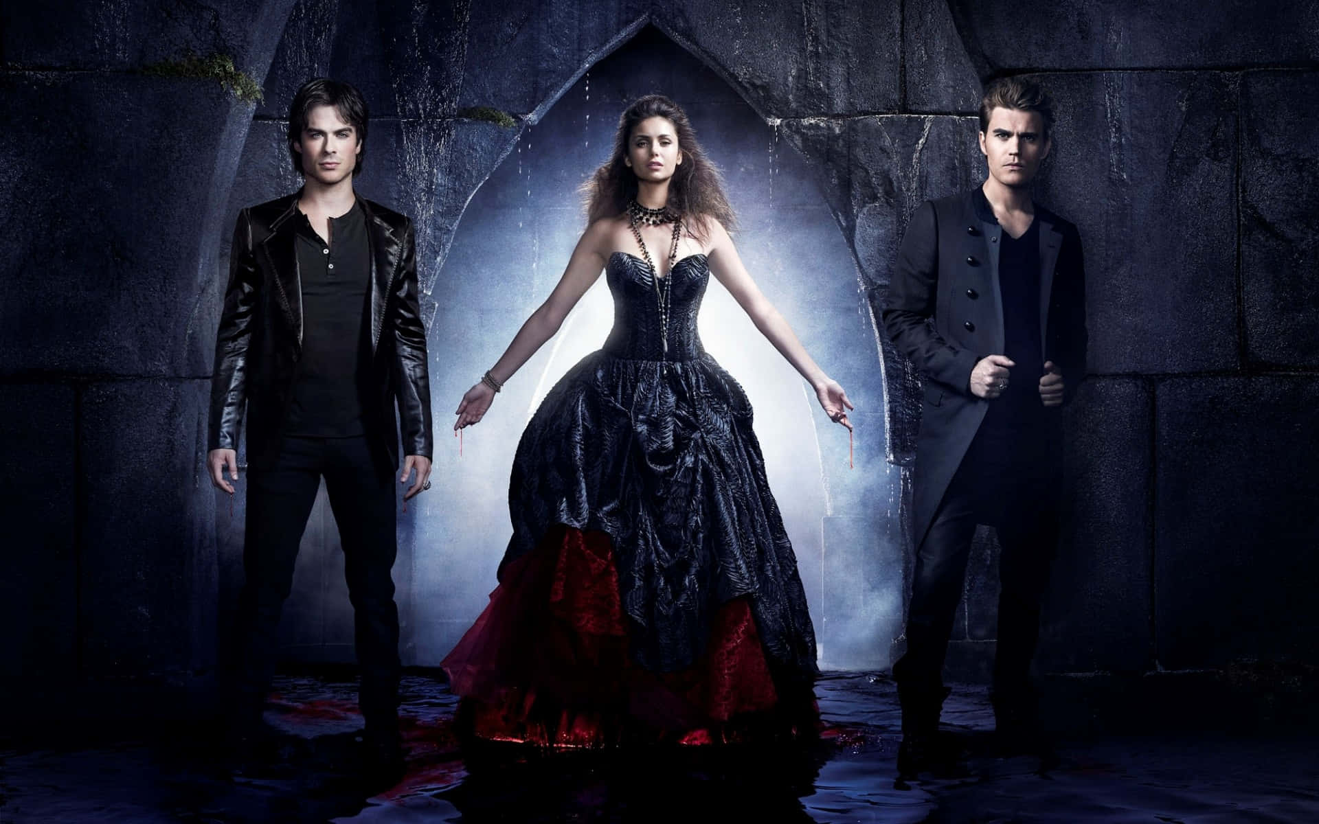 Vampire Diaries Desktop 桌布 壁紙 — 三個哥德式人物站在石拱門中，帶有詭異的藍色背光和紅色布料點綴。
