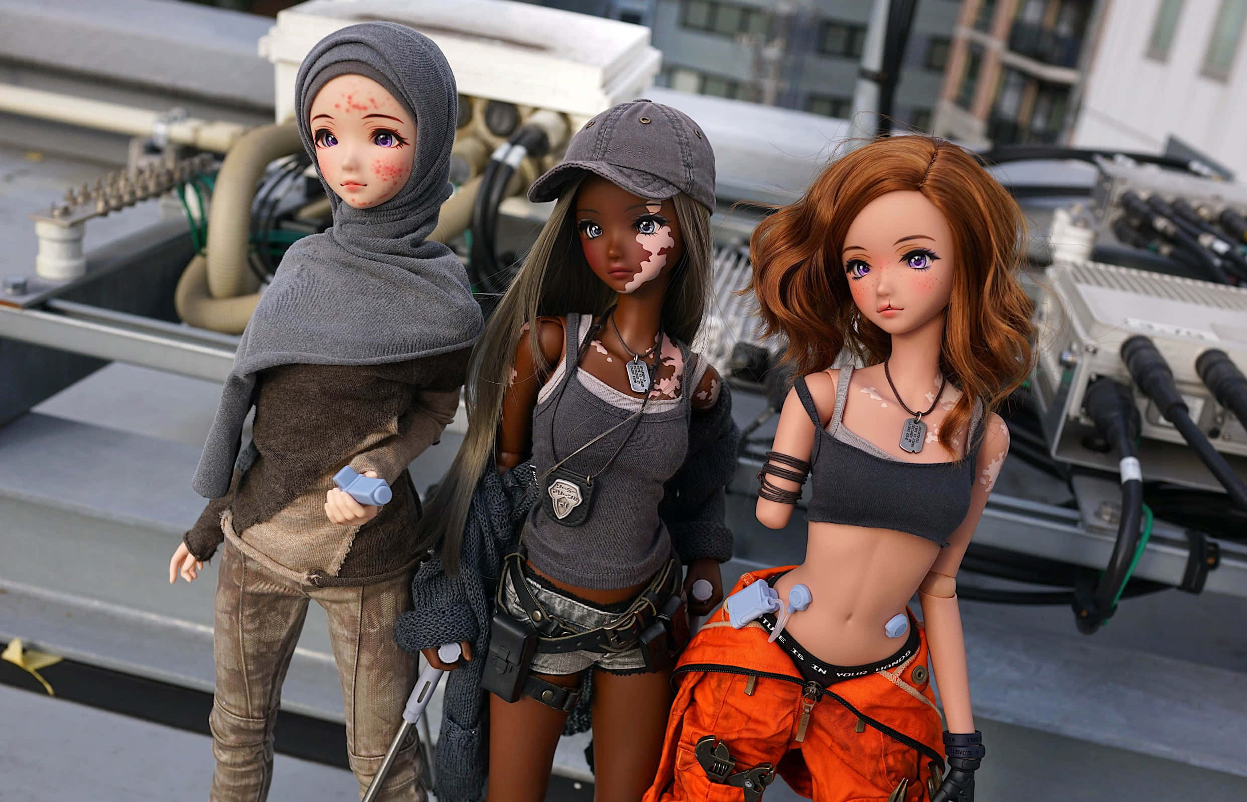 Dolls 桌布 壁紙 — 三個帶有戰鬥傷痕的動漫風格人偶站在屋頂上，周圍是工業設備和城市建築。