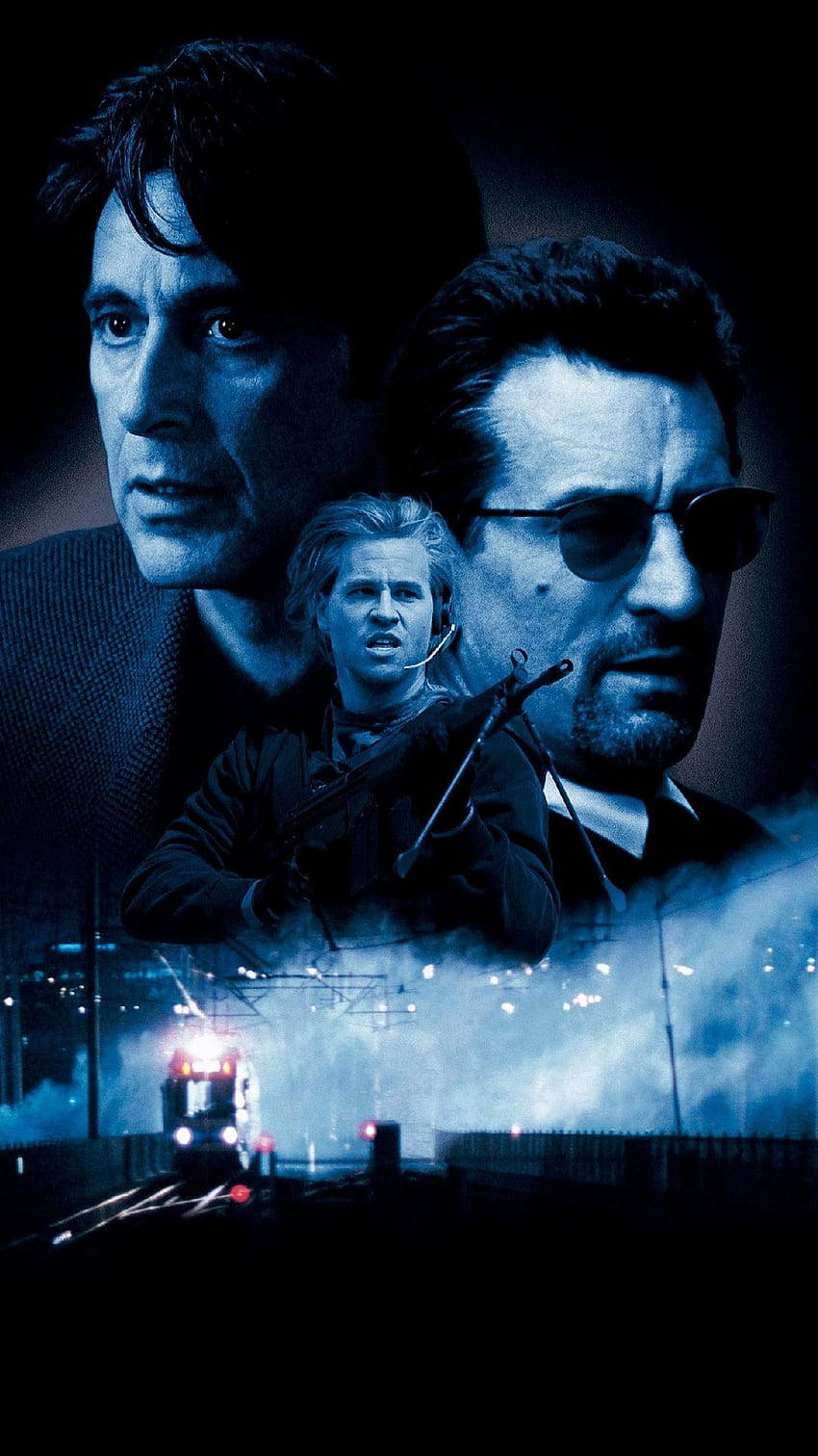 Val Kilmer 桌布 壁紙 — 三個強烈的男性面孔在黑暗的城市景觀上空浮現，一列火車在藍色燈光下駛近。