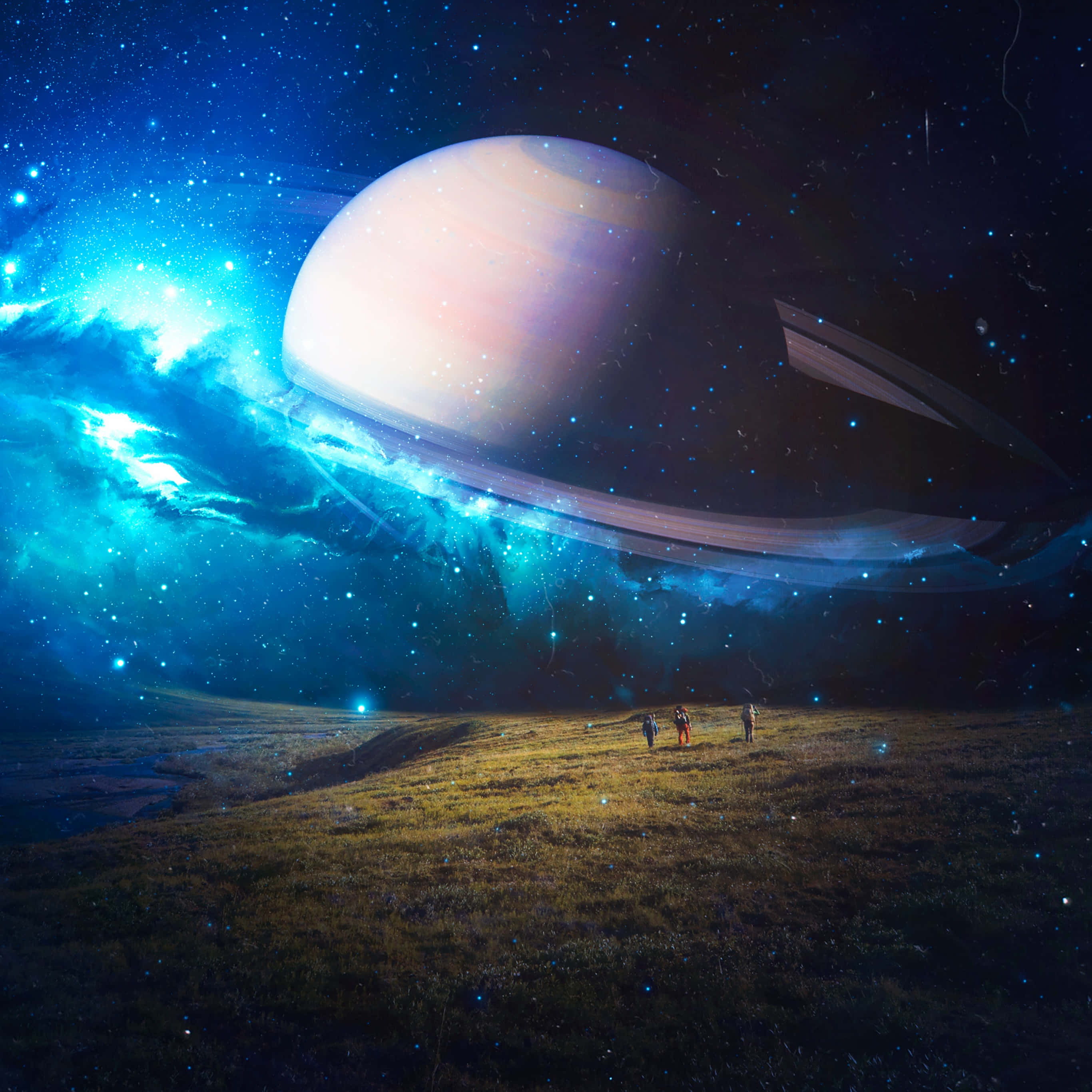 土星 桌布 壁紙 — 三個微小的人物站在一片草地上，上方是一個巨大的土星，散發著宇宙藍色星雲和星星的光芒。
