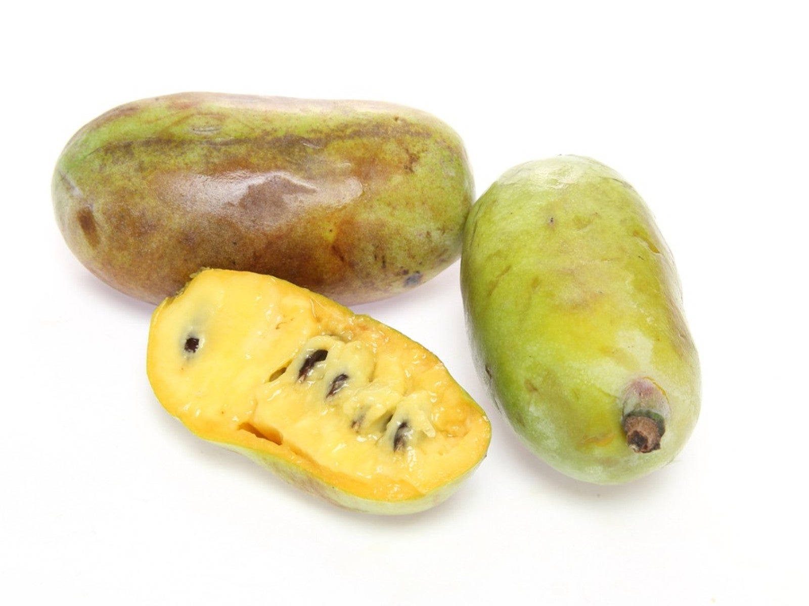 Fruit 桌布 壁紙 — 三個成熟的馬米果，其中一個切開，露出鮮黃色的果肉和黑色的種子，背景是純白色。