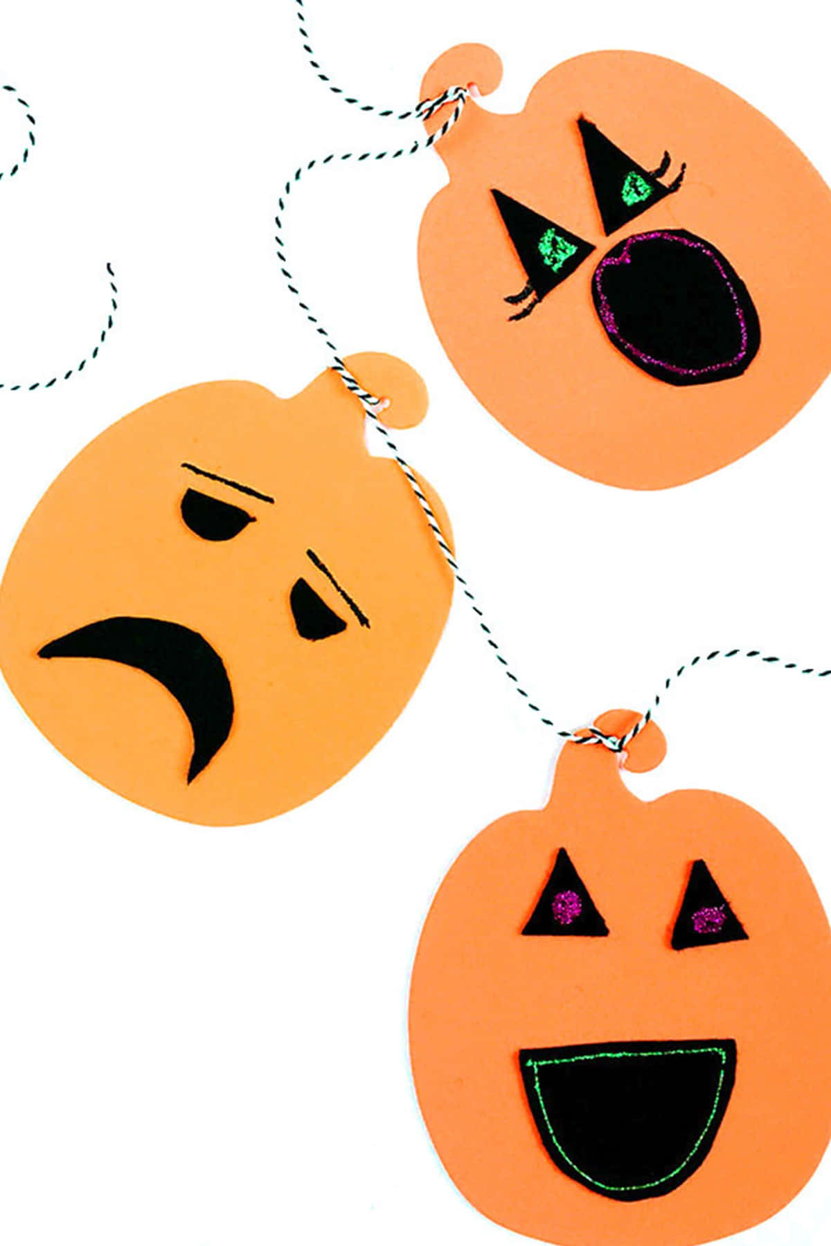 Halloween Crafts 桌布 壁紙 — 三個手工製作的橙色紙南瓜，帶有縫製的臉孔，懸掛在白色背景前。