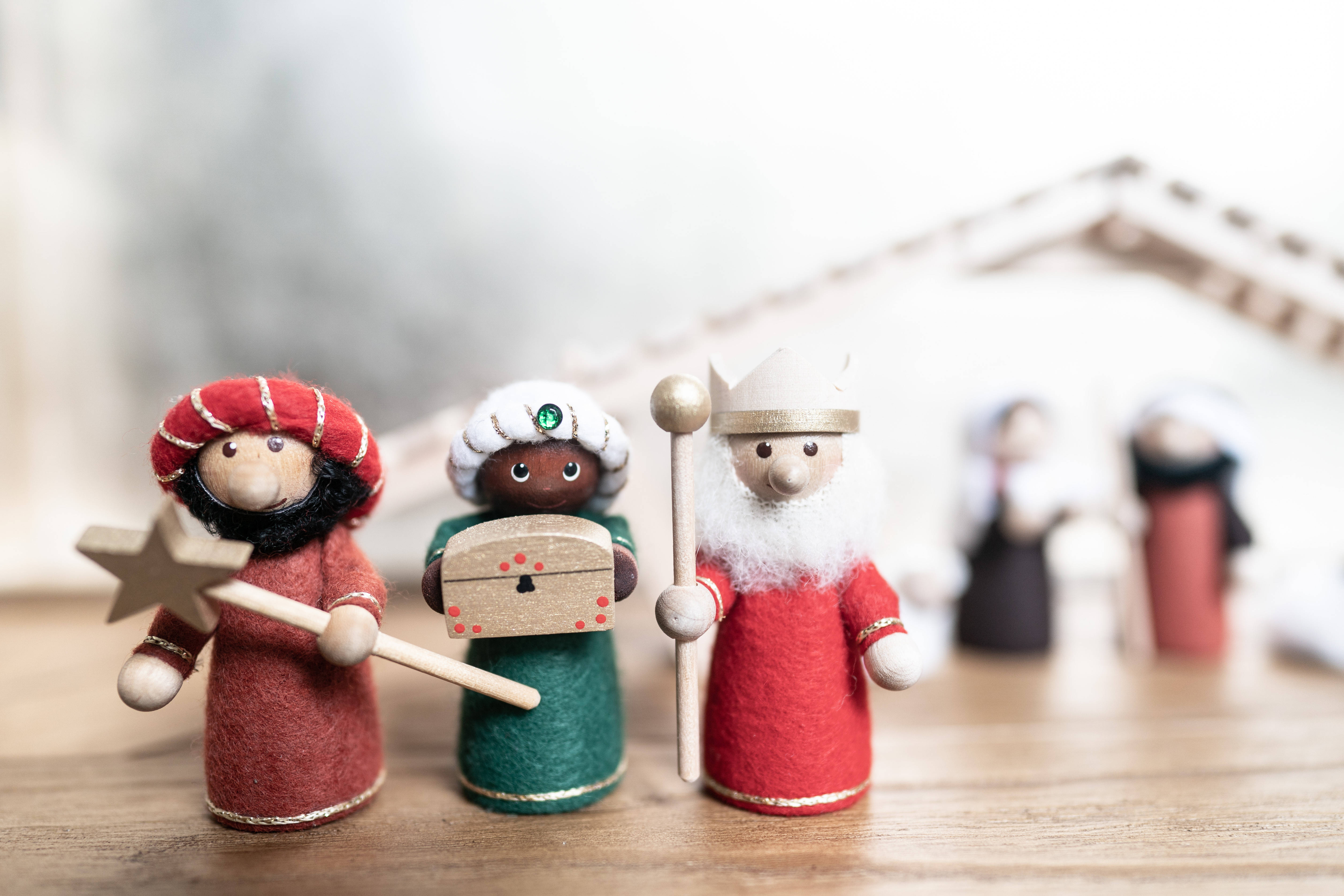 Nativity 桌布 壁紙 — 三個手工製作的氈製三位智者雕像，站在木質表面上，景深較淺。