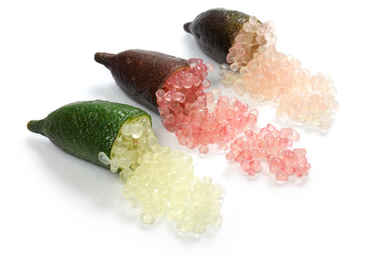 Fruits 桌布 壁紙 — 三個手指檸檬切開，半透明粉紅色和淡黃色魚子醬般的珍珠灑落在純白表面上。