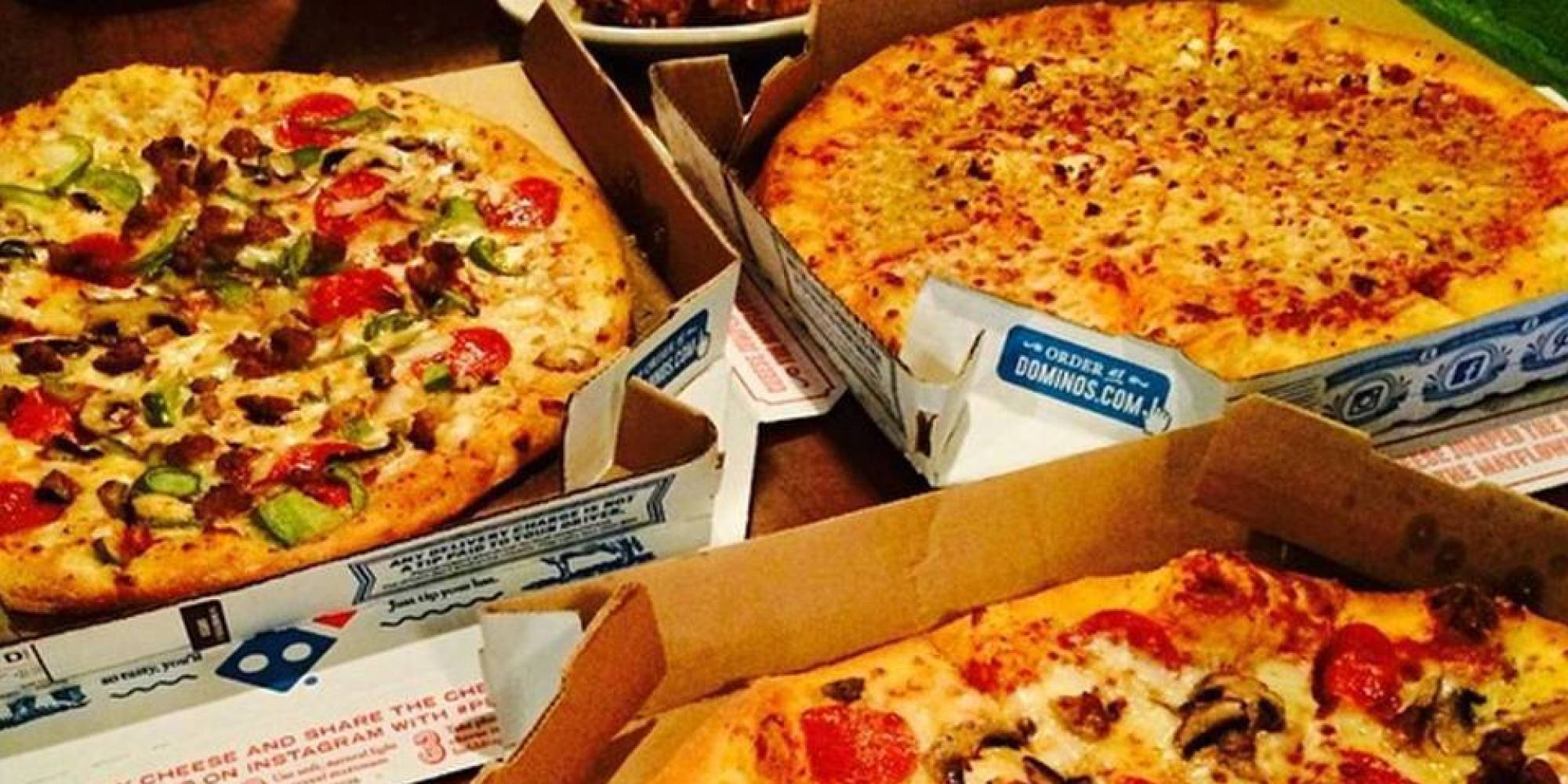 Dominos Pizza 桌布 壁紙 — 三個打開的Domino's披薩盒展示出起司辣肉腸、香腸和蘑菇披薩，搭配金黃色的餅皮。