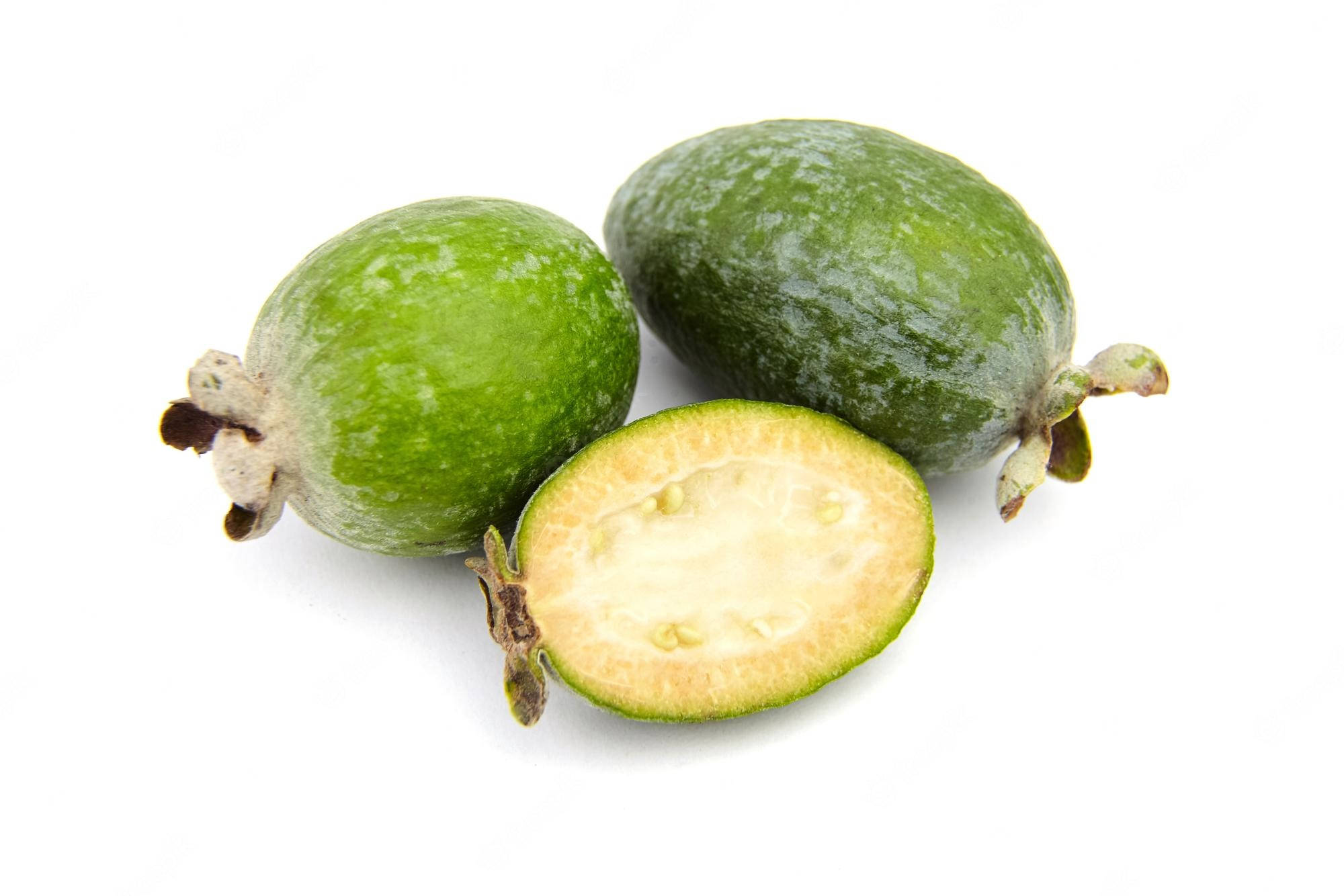 Fruit 桌布 壁紙 — 三個新鮮的菲油果，其中一個切半，露出淡黃色的果肉和細小的種子，背景是純白色。
